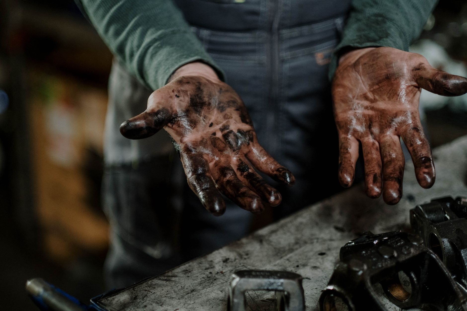 A close-up of a dirty concrete service bay floor with dark oil and grease stains, illustrating a tough cleaning challenge.