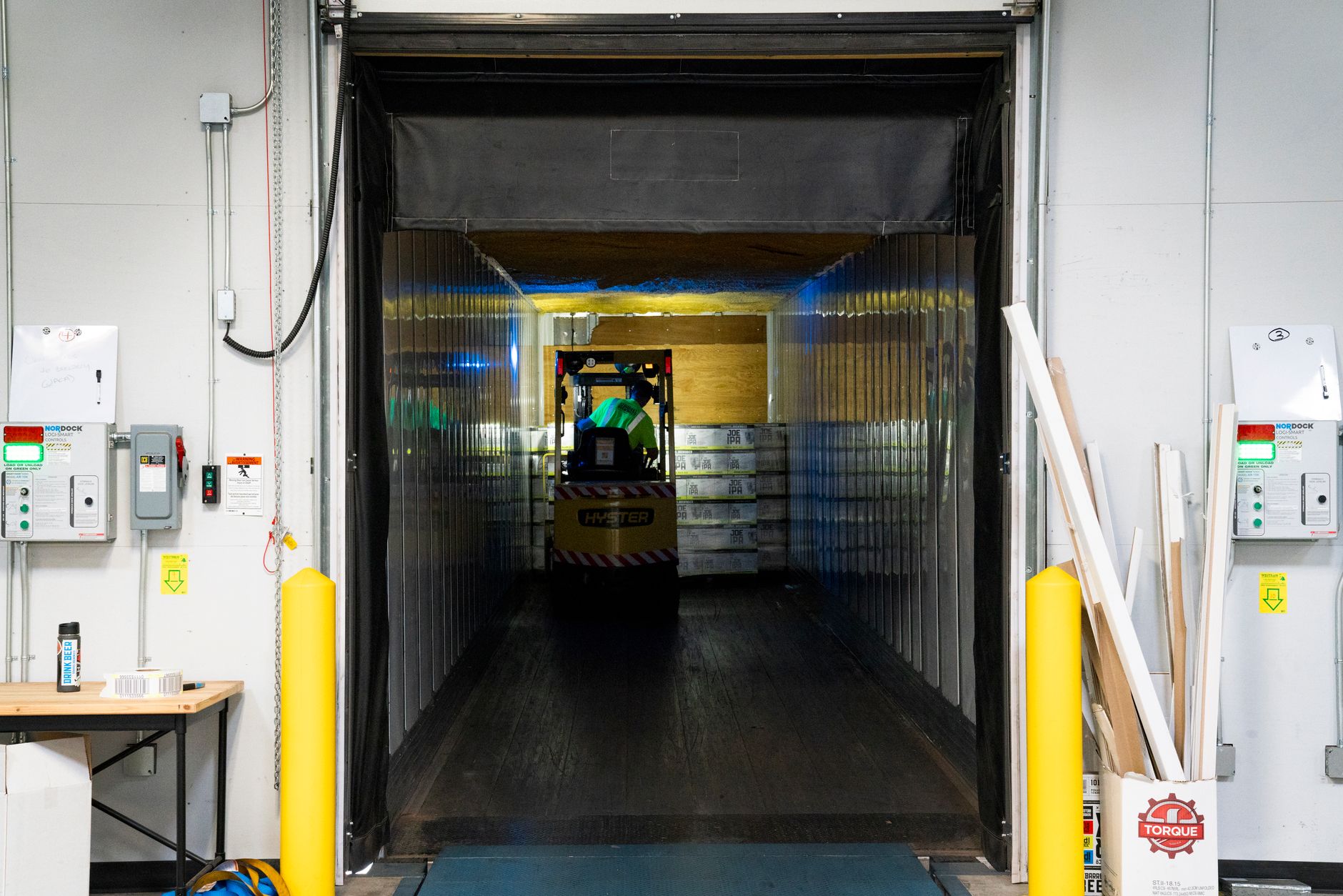 A forklift operates in a warehouse aisle, representing the kind of powered industrial truck whose risks are a major focus of OSHA inspections.
