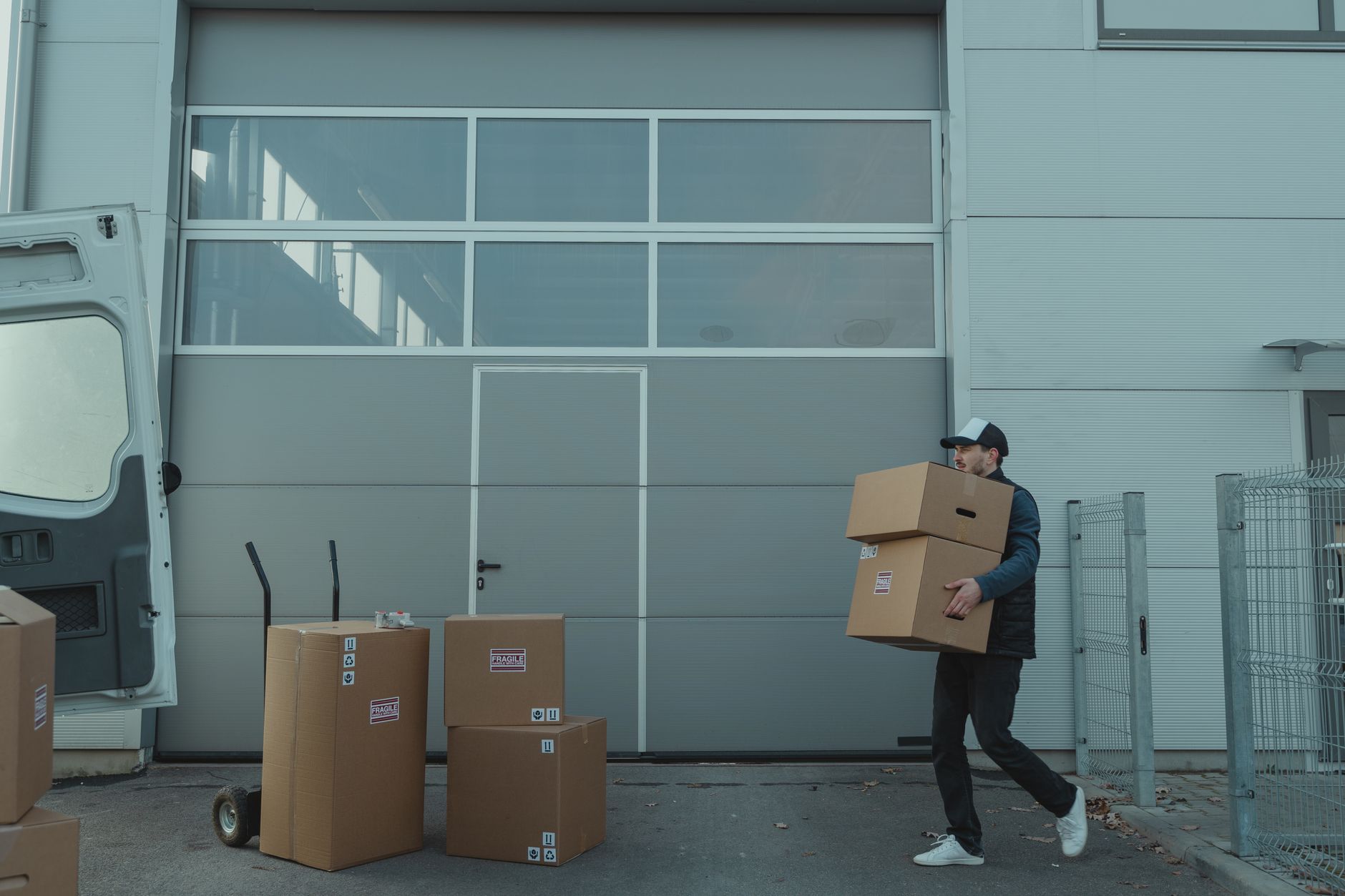A warehouse employee bends to lift a heavy box, illustrating the type of manual material handling that can lead to ergonomic injuries.
