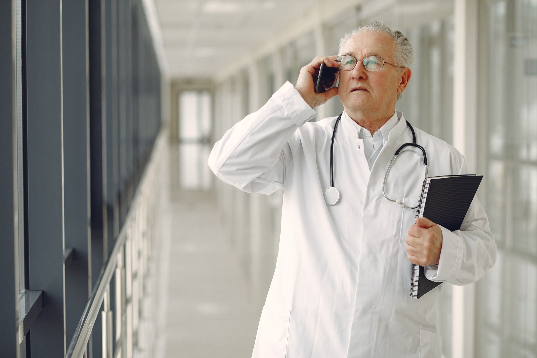 A doctor walks down a modern hospital hallway, illustrating an environment where safety sensors must detect human presence.