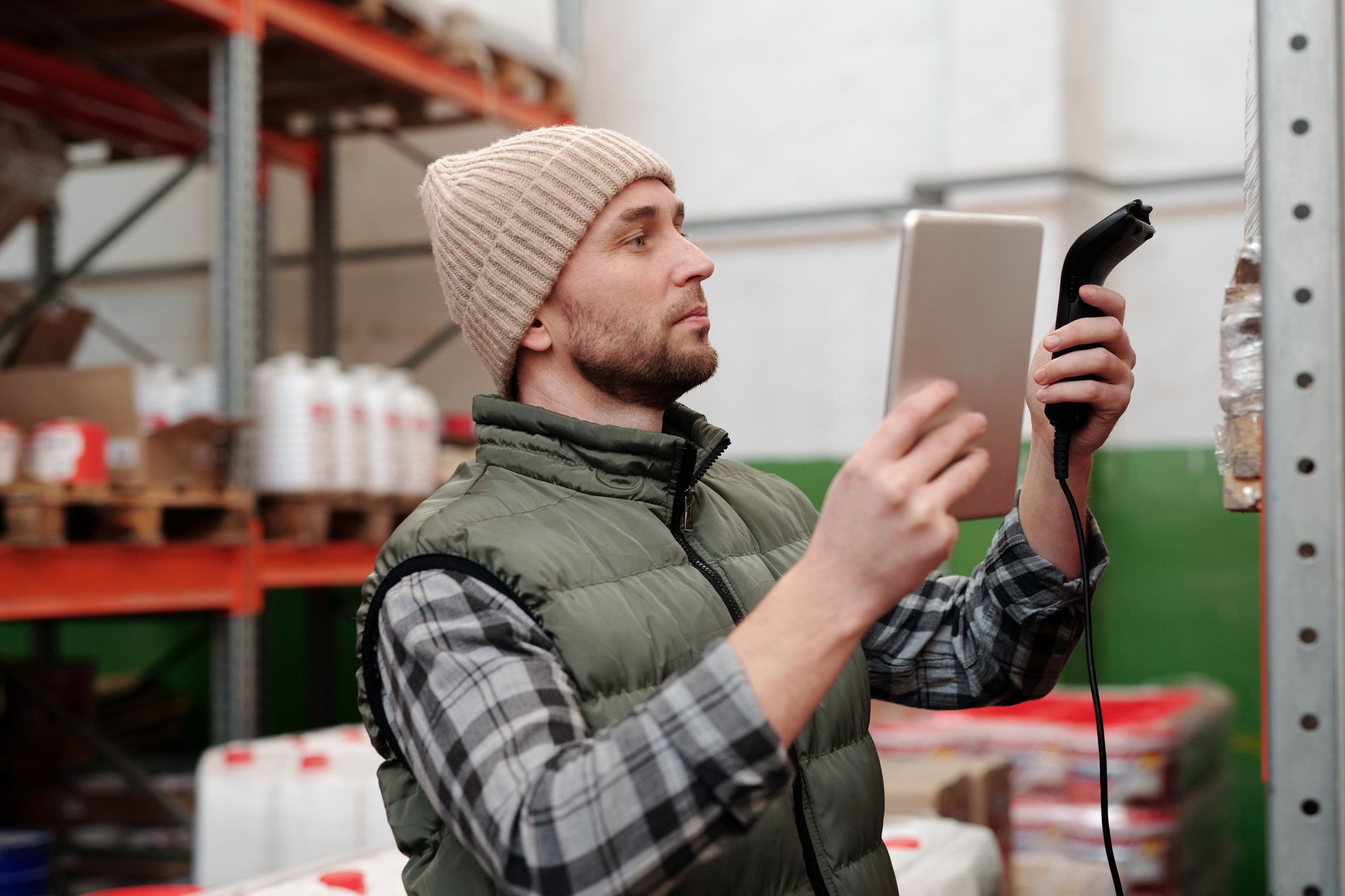 A warehouse employee uses a tablet to manage inventory, illustrating the shift to higher-skilled roles in an automated facility.