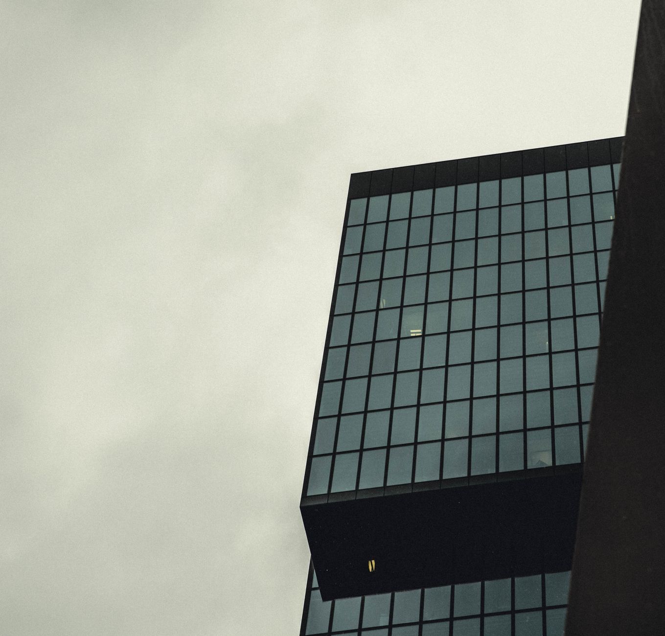 View from the top of a modern skyscraper, looking down at the street below, emphasizing the extreme height involved in window cleaning.