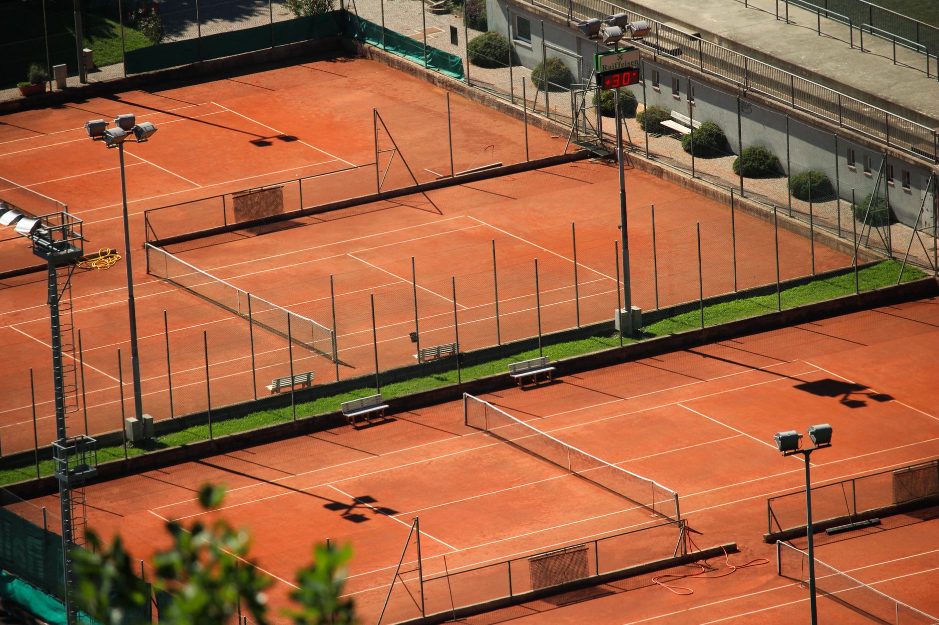 A worker cleans an empty tennis court during an off-peak maintenance window.