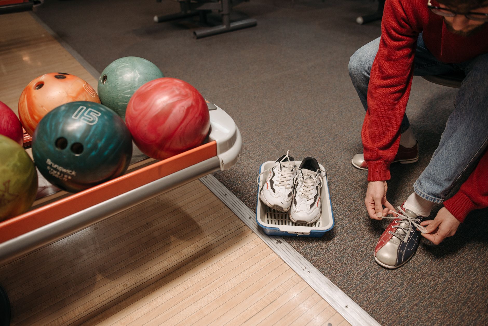 Bowling shoe rental counter where foot traffic tracks grit onto nearby tile floors.