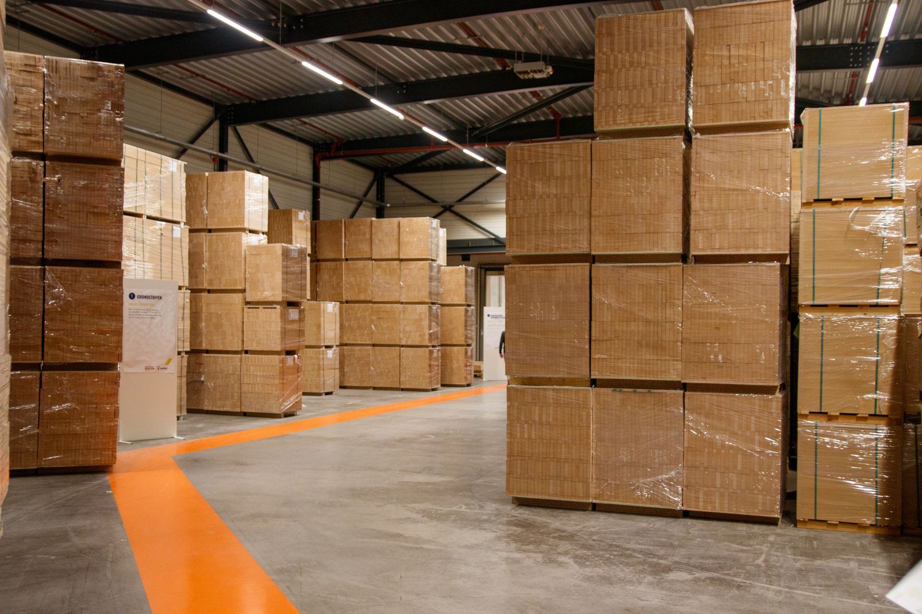 Yellow safety lines and markings on a polished concrete warehouse floor, illustrating the complex operational paths that automation systems must navigate.
