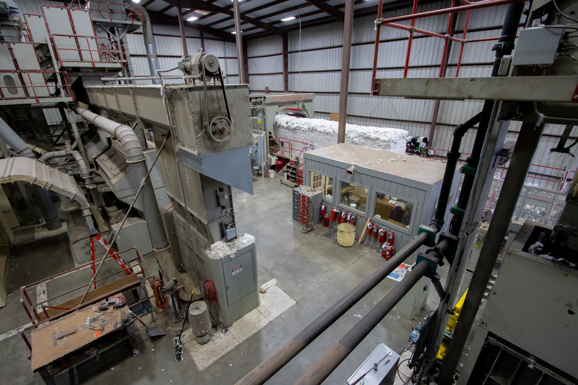 Overhead material handling rails above a factory floor, similar to monorail paint loops.