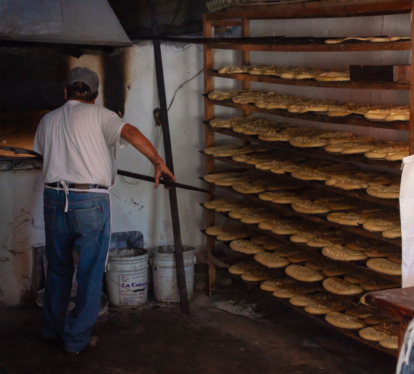 Empty rolling bakery racks staged for movement through a commercial production area.