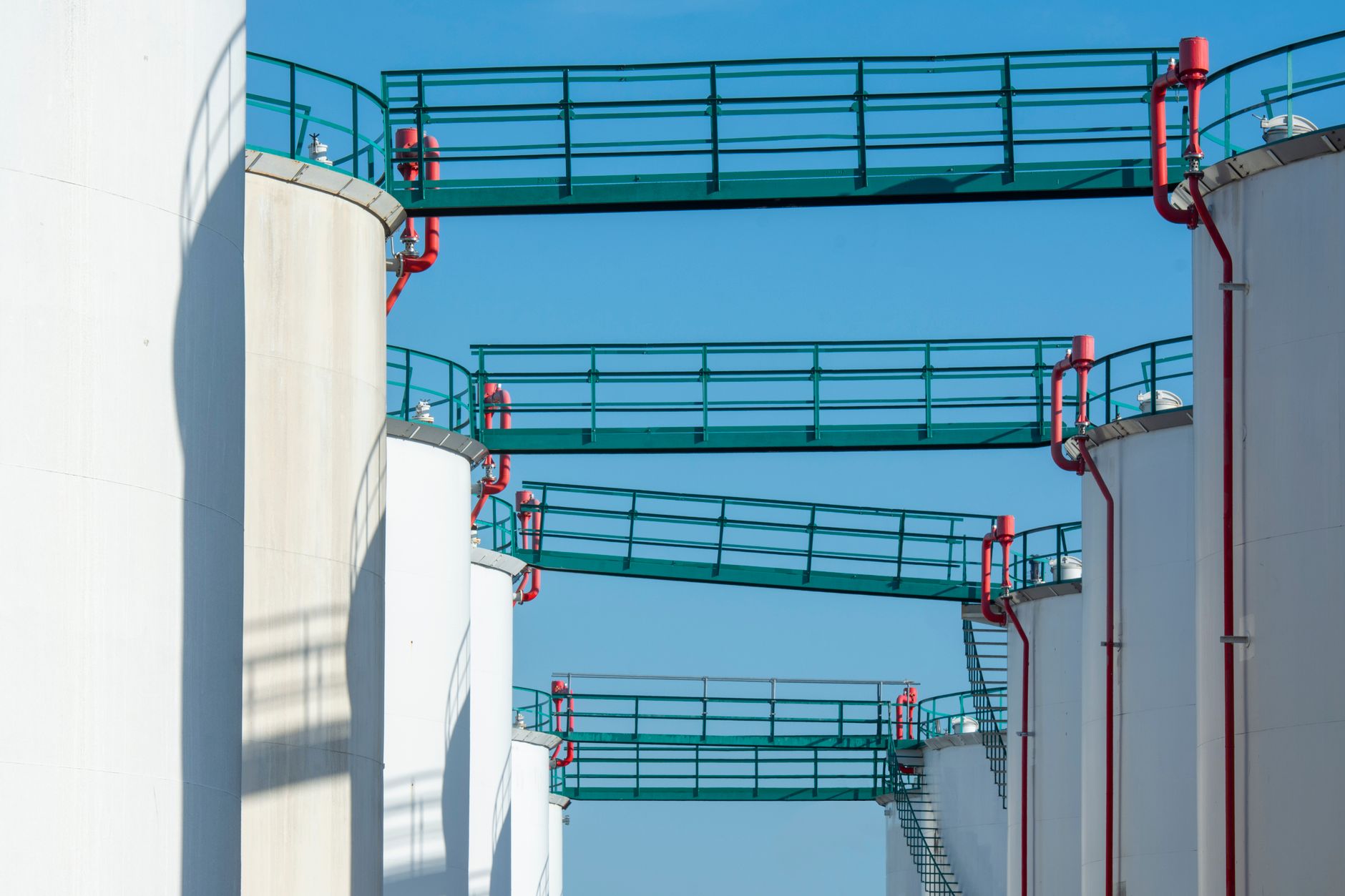A marked pedestrian walkway runs through pipework at a chemical processing plant.