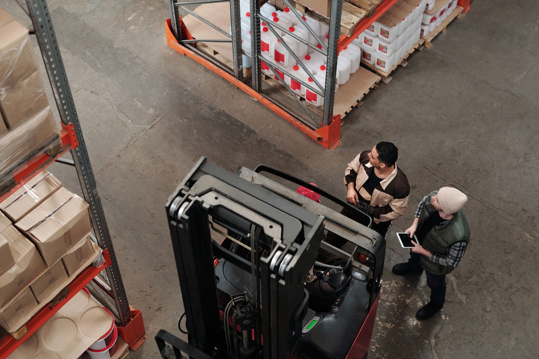 A warehouse employee works carefully in an active aisle where safe handoffs and clear operating space matter.