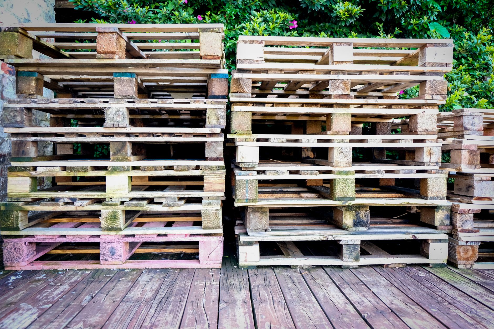 Stacked wooden pallets staged near a loading area, illustrating consolidation and damage checks.