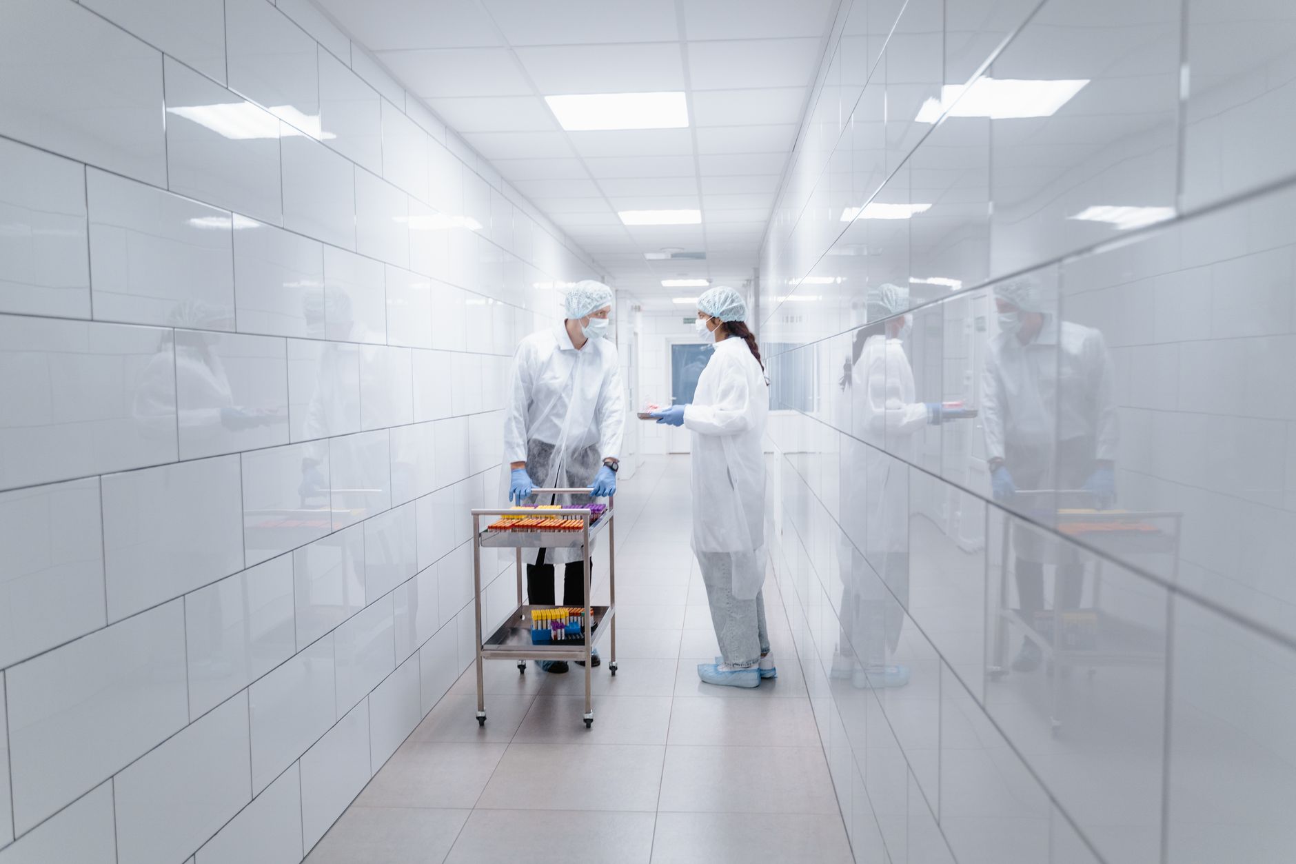 Hospital laboratory corridor where empty specimen trays return toward wash and storage areas.