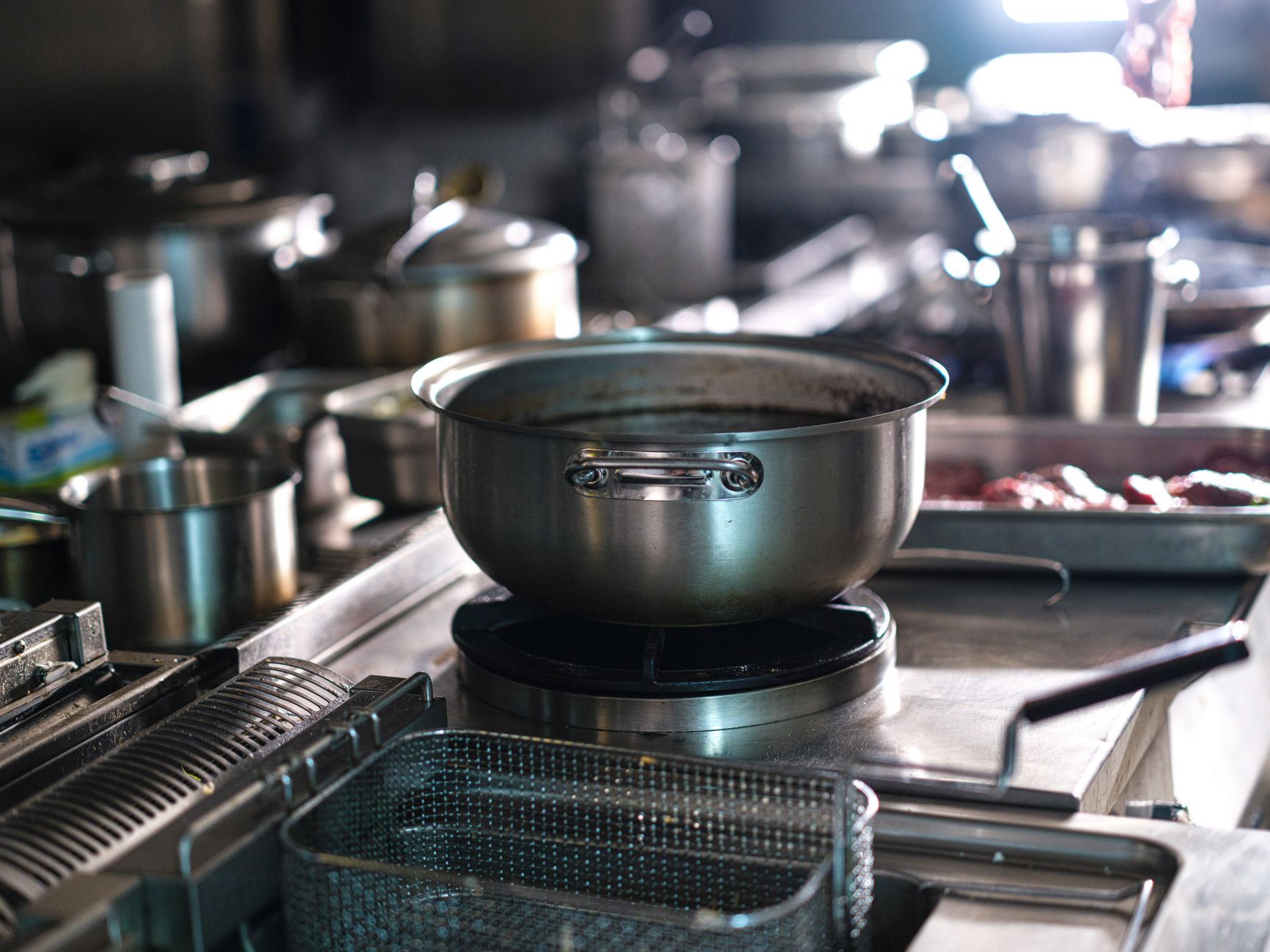 A hotel production kitchen with stainless prep tables where food-waste carts start their route to disposal.
