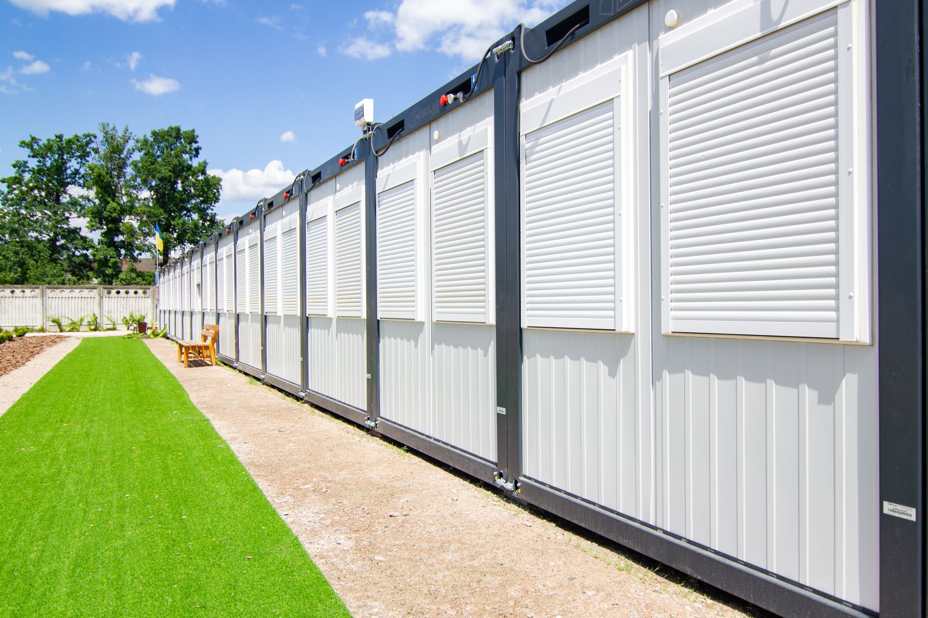 Workers assemble wall panels inside an off-site modular construction plant.