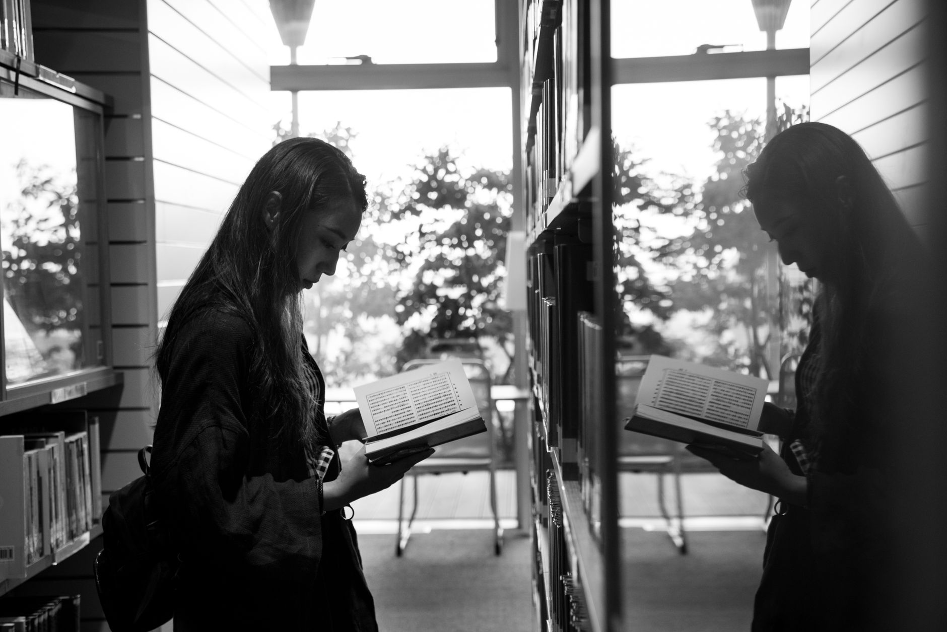 Patrons reading at tables in a quiet library where equipment noise must remain unobtrusive.
