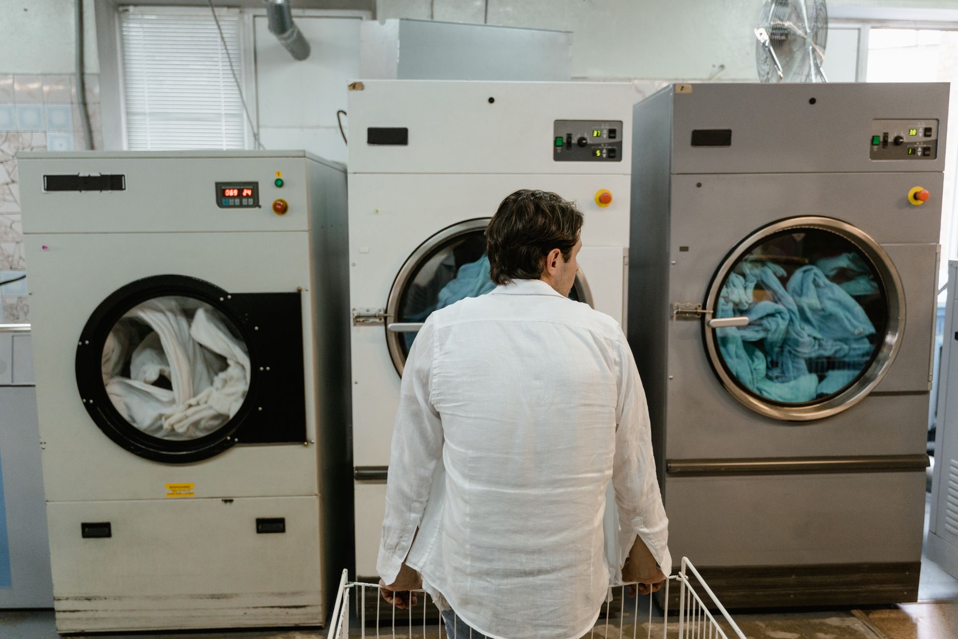 The clean, bright interior of a large-scale commercial laundry facility, the starting point for linen transport in a resort.