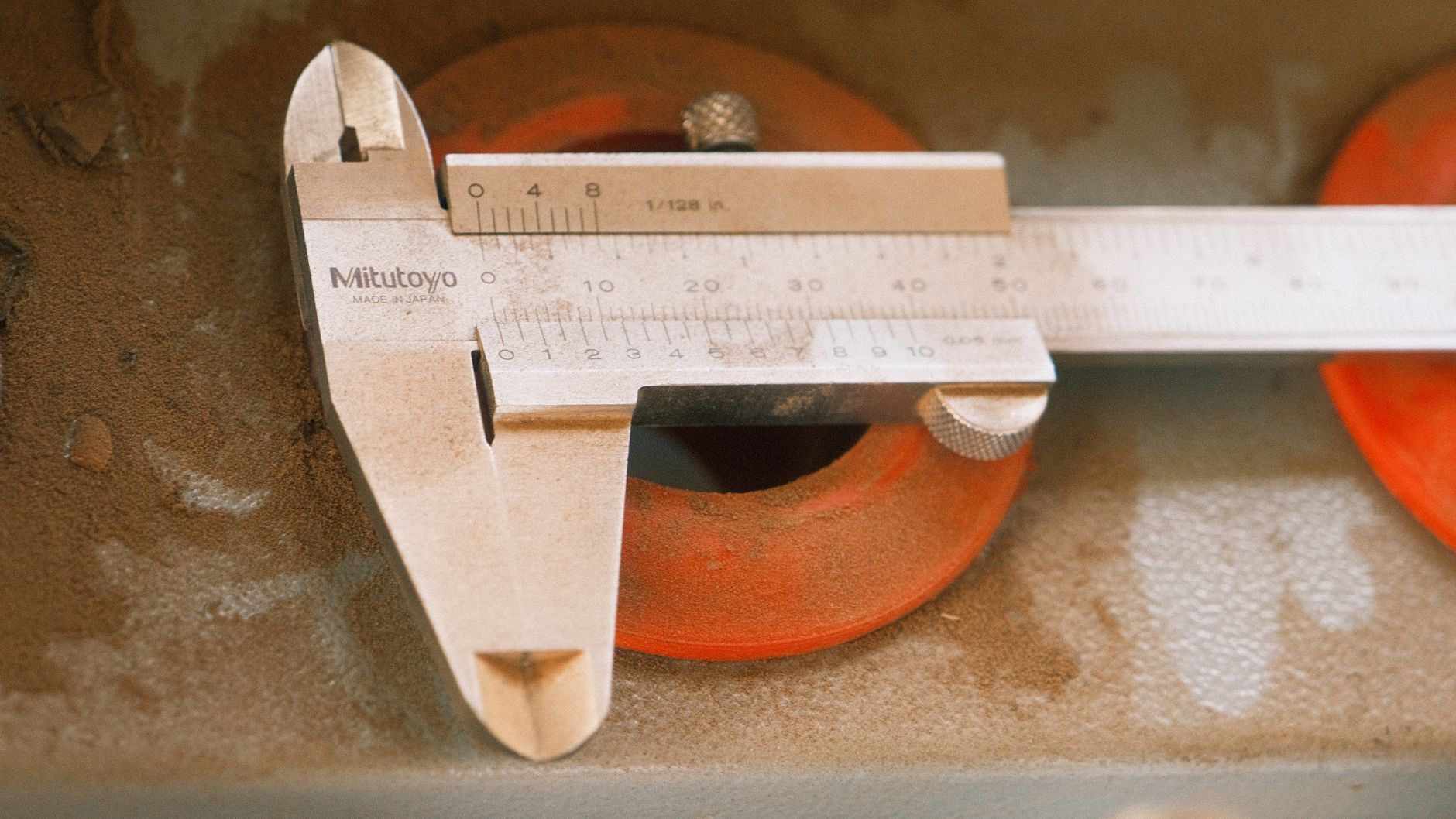 A machinist checks a steel component with a precision measuring instrument before installation.