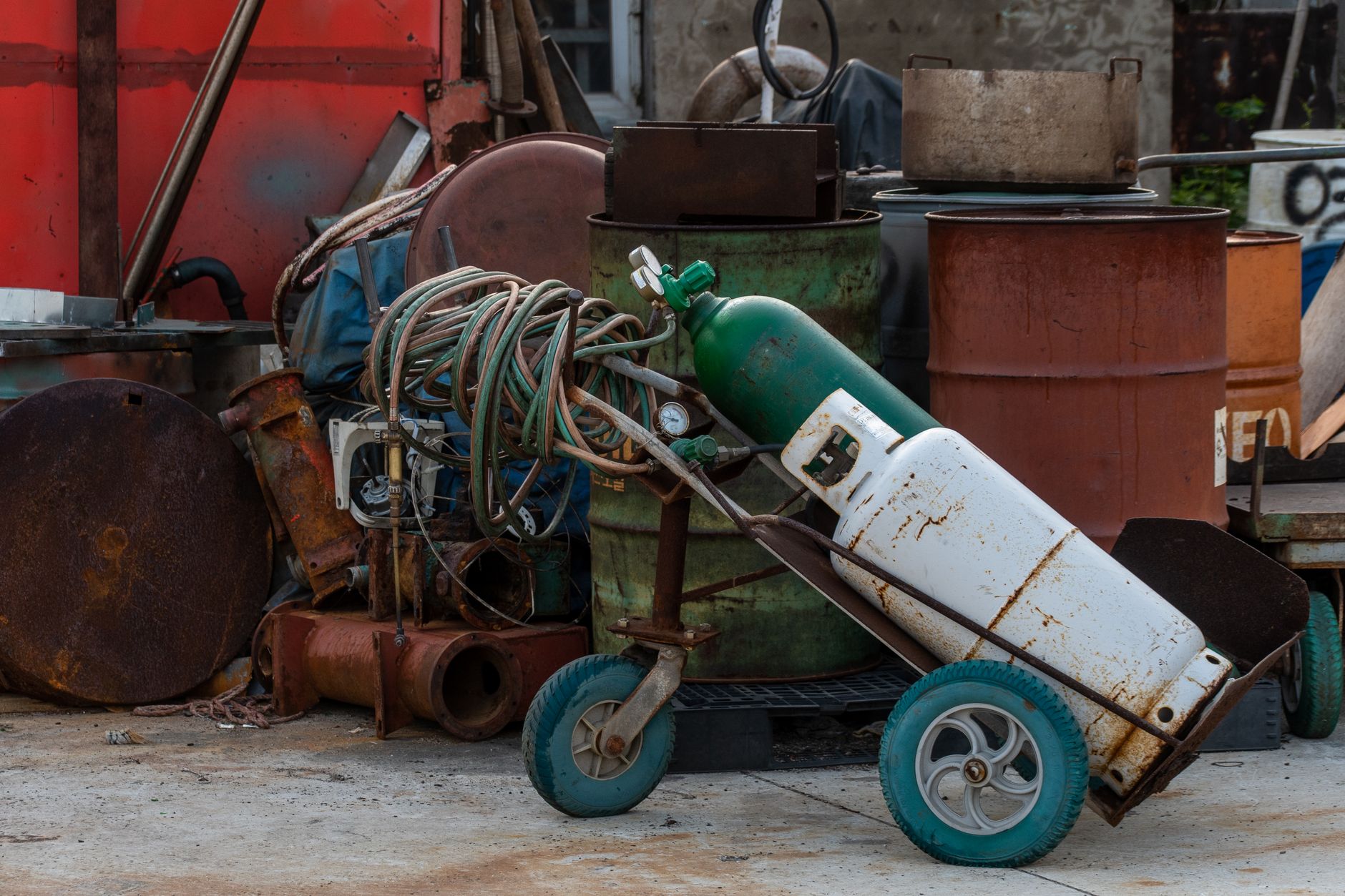 Capped oxygen cylinders strapped upright to a transport cart show the secure fixture the article calls for during movement.