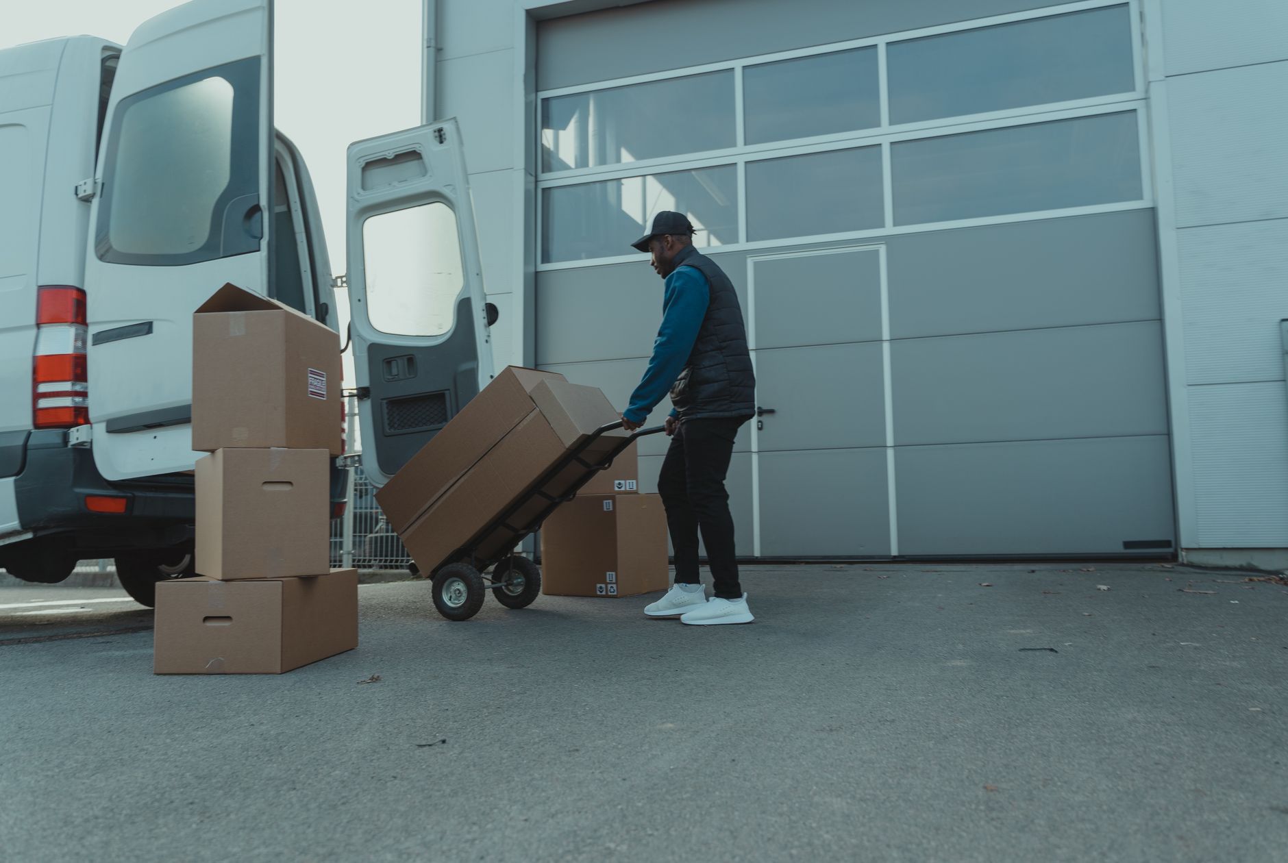 A warehouse worker moving inbound cartons from a receiving area for branch replenishment.