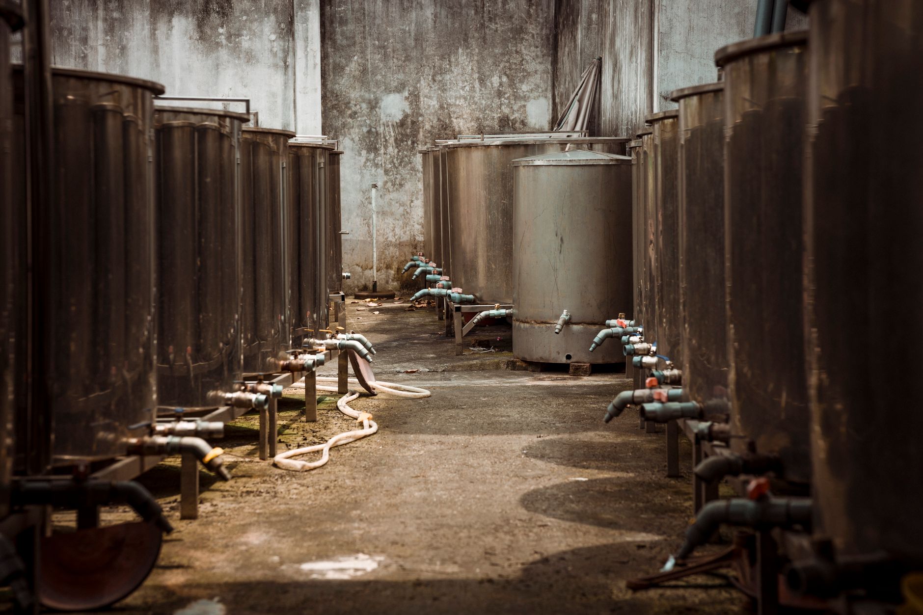 A compact plumbing supply warehouse with boxed inventory and pipe stock arranged along shelving aisles.