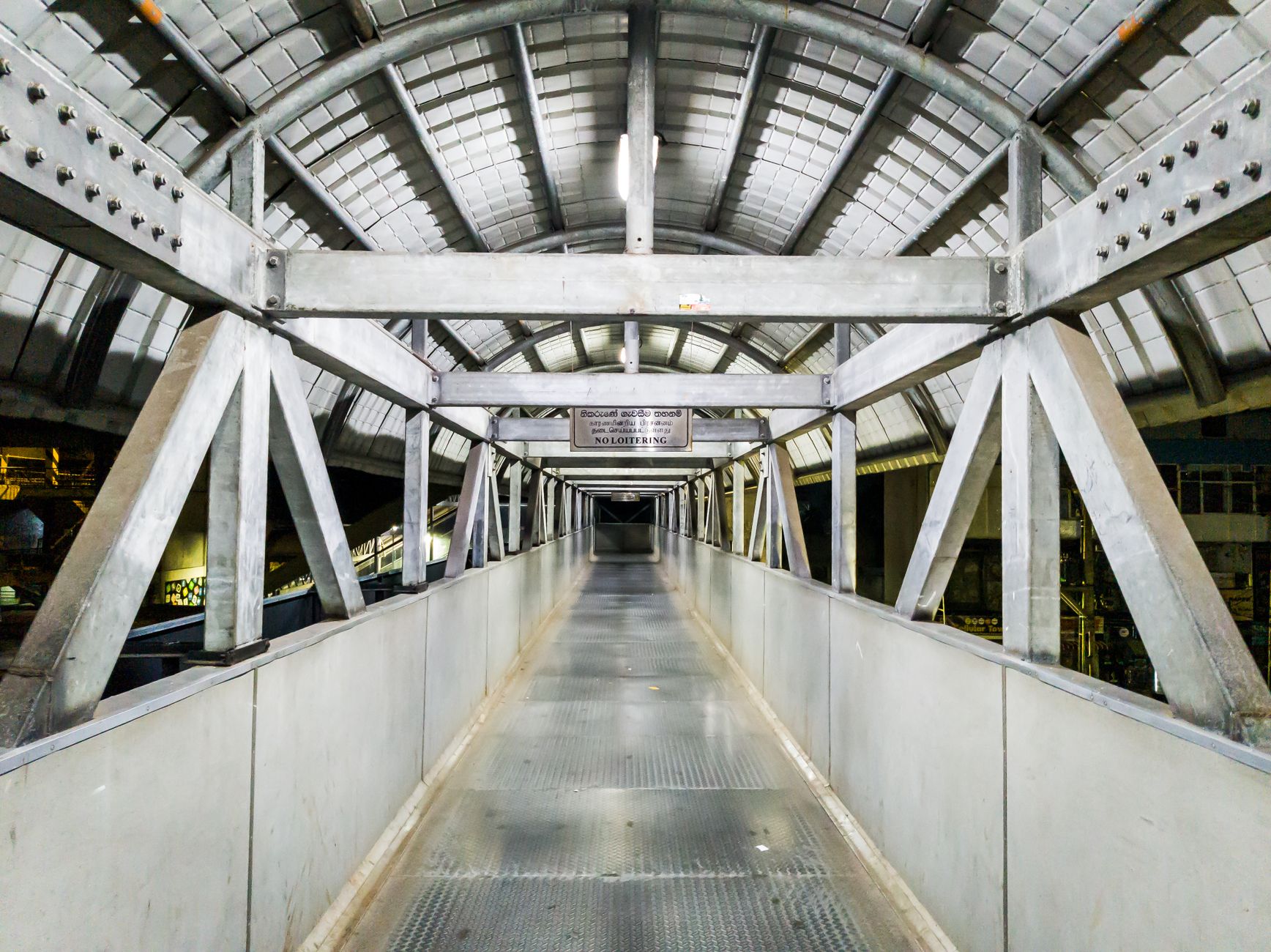 Stainless corridor in a food facility where hygiene rules govern traffic flow.