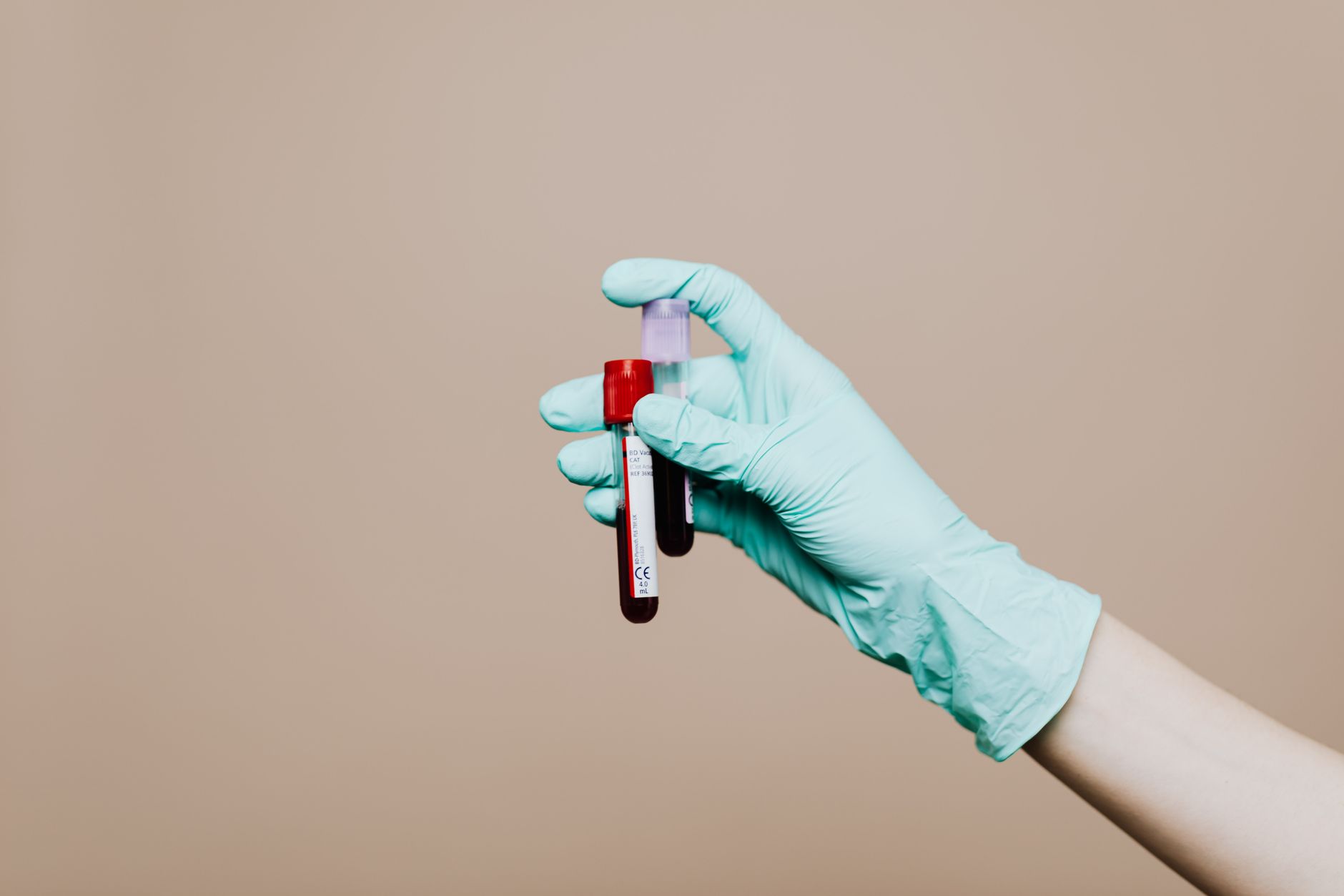 A careful handoff of lab materials between staff, reinforcing where human judgment still belongs in sample and supply movement.