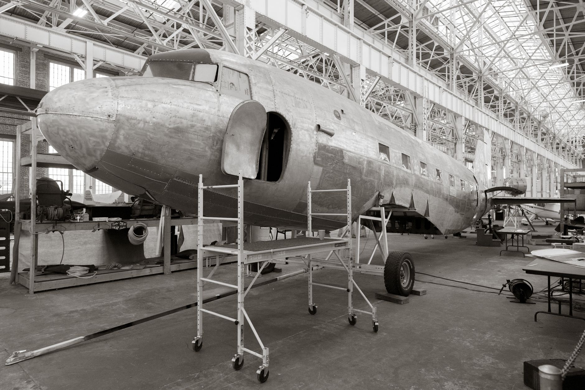 Workers prepare composite aircraft structures inside a large aerospace manufacturing hangar.