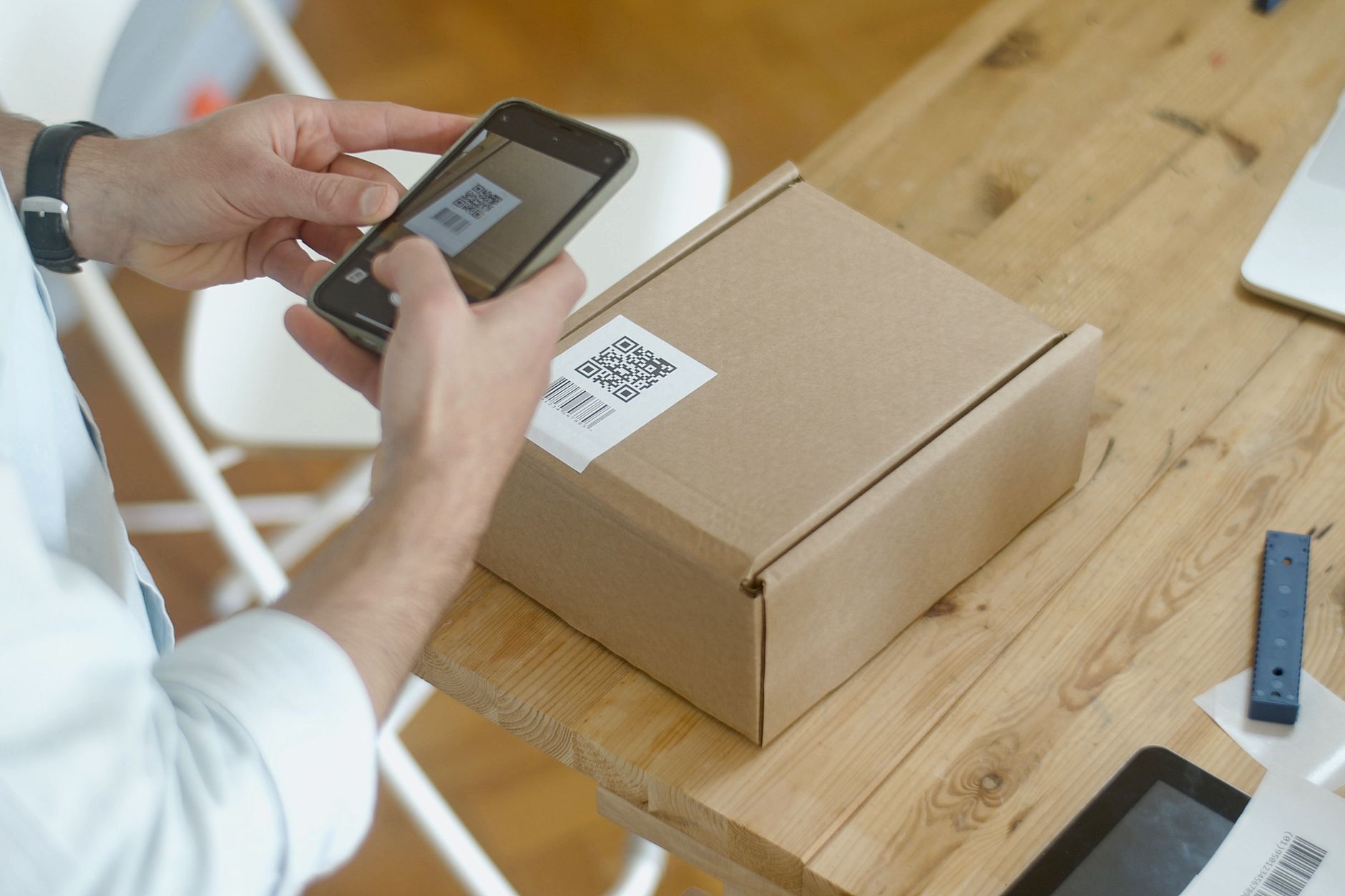 Close view of a worker scanning labels on cartons to confirm product and location during a controlled internal move.