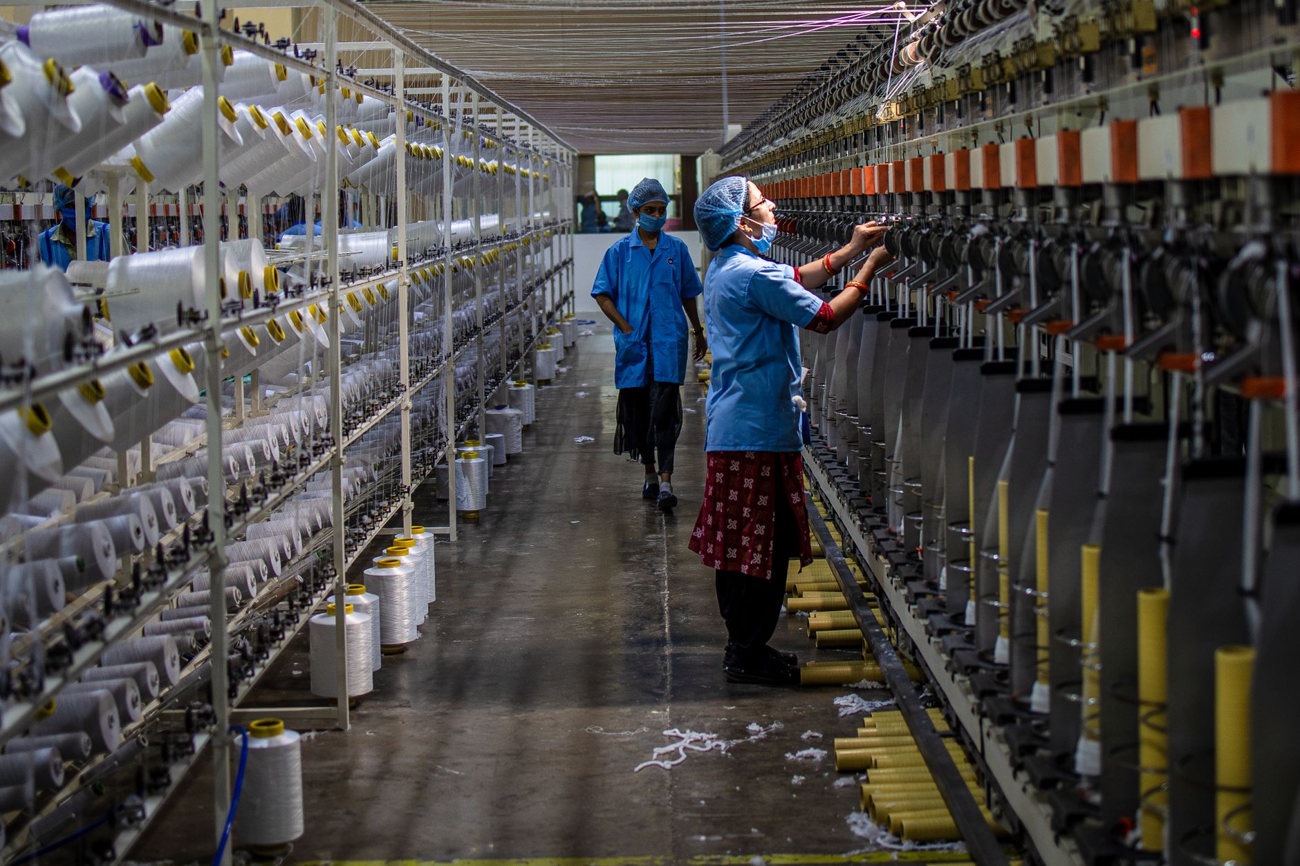 Organized yarn spools stored in labeled inventory locations for production use.