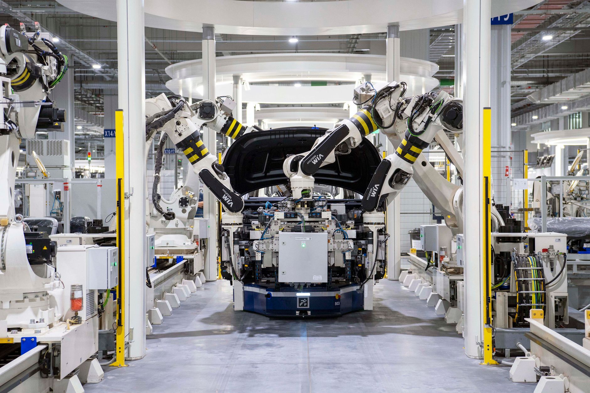 A wide, clean automotive factory floor, representing the structured environment where humanoid robots are first being deployed in 2026.