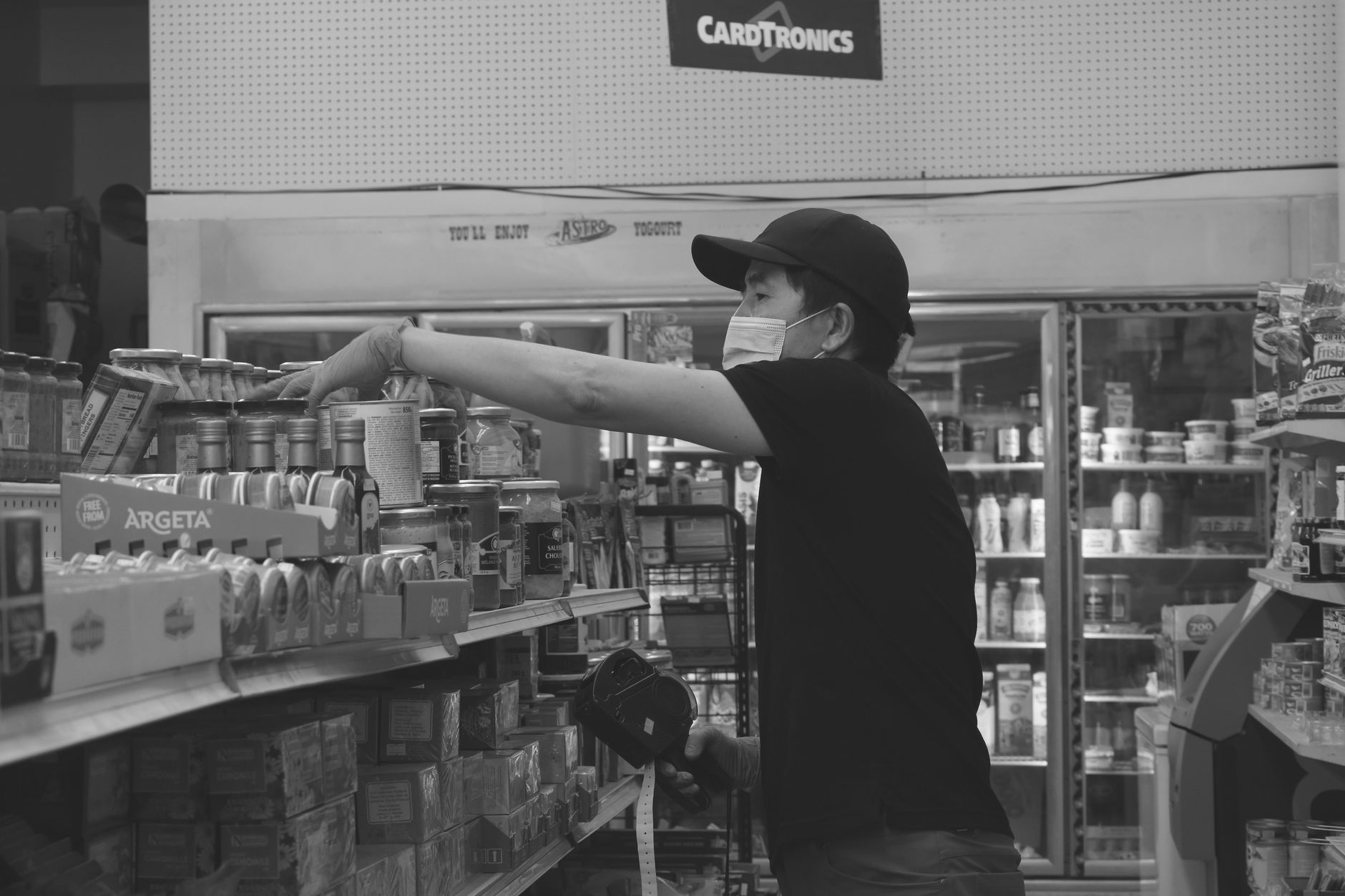 Grocery associate stocking products on a store shelf