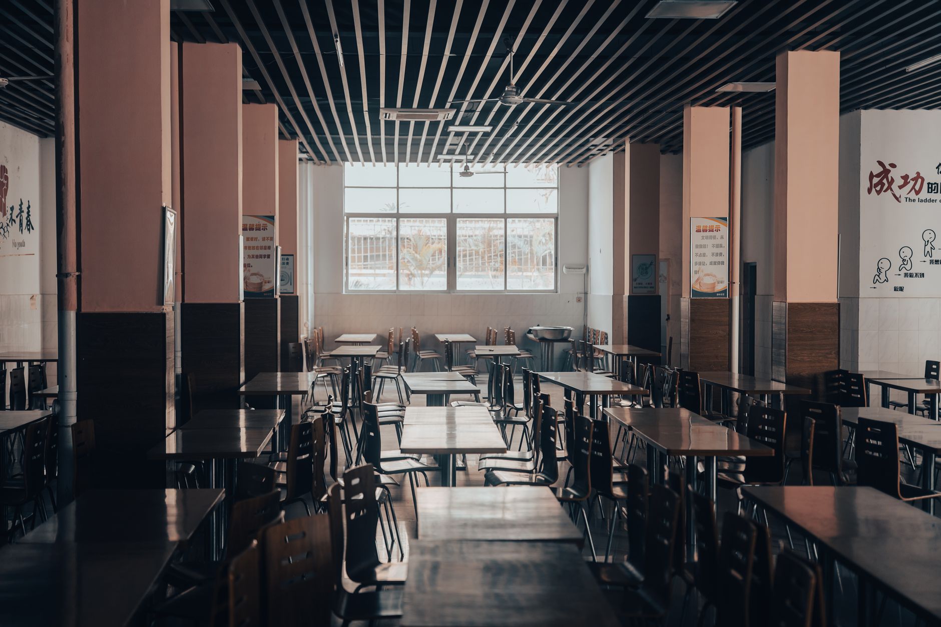 A bustling, high-volume cafeteria during peak hours, illustrating the constant challenge of keeping tables clear for the next diners.