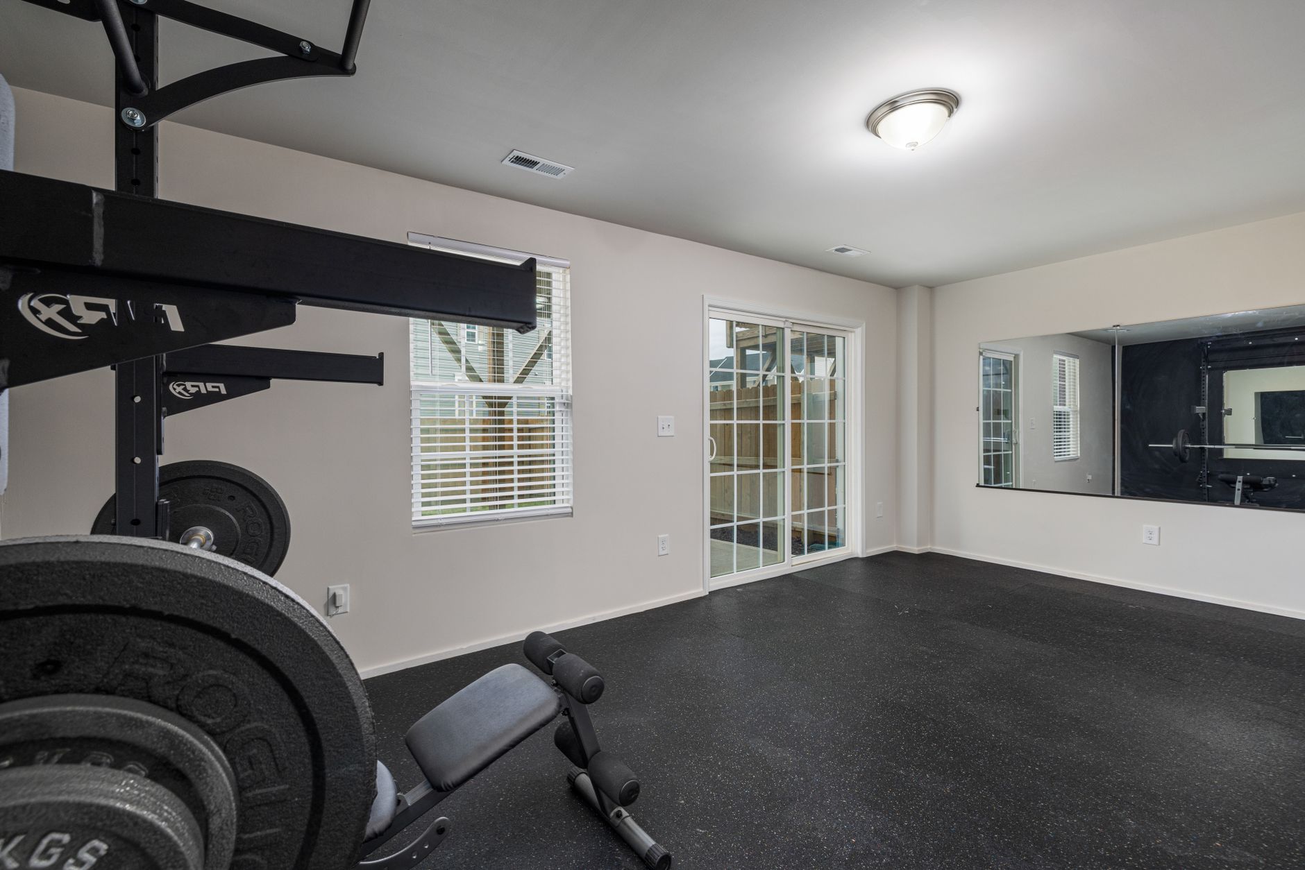 A weight room with rows of heavy, stationary equipment, illustrating a complex floor layout for cleaning.