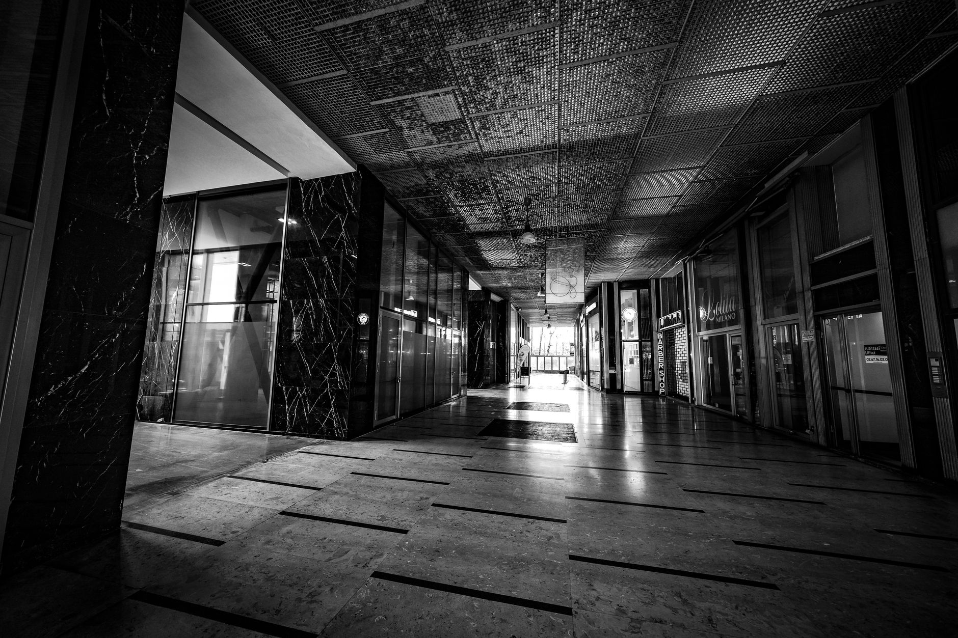 Rainwater tracked across entrance mats onto the floor of a public terminal.
