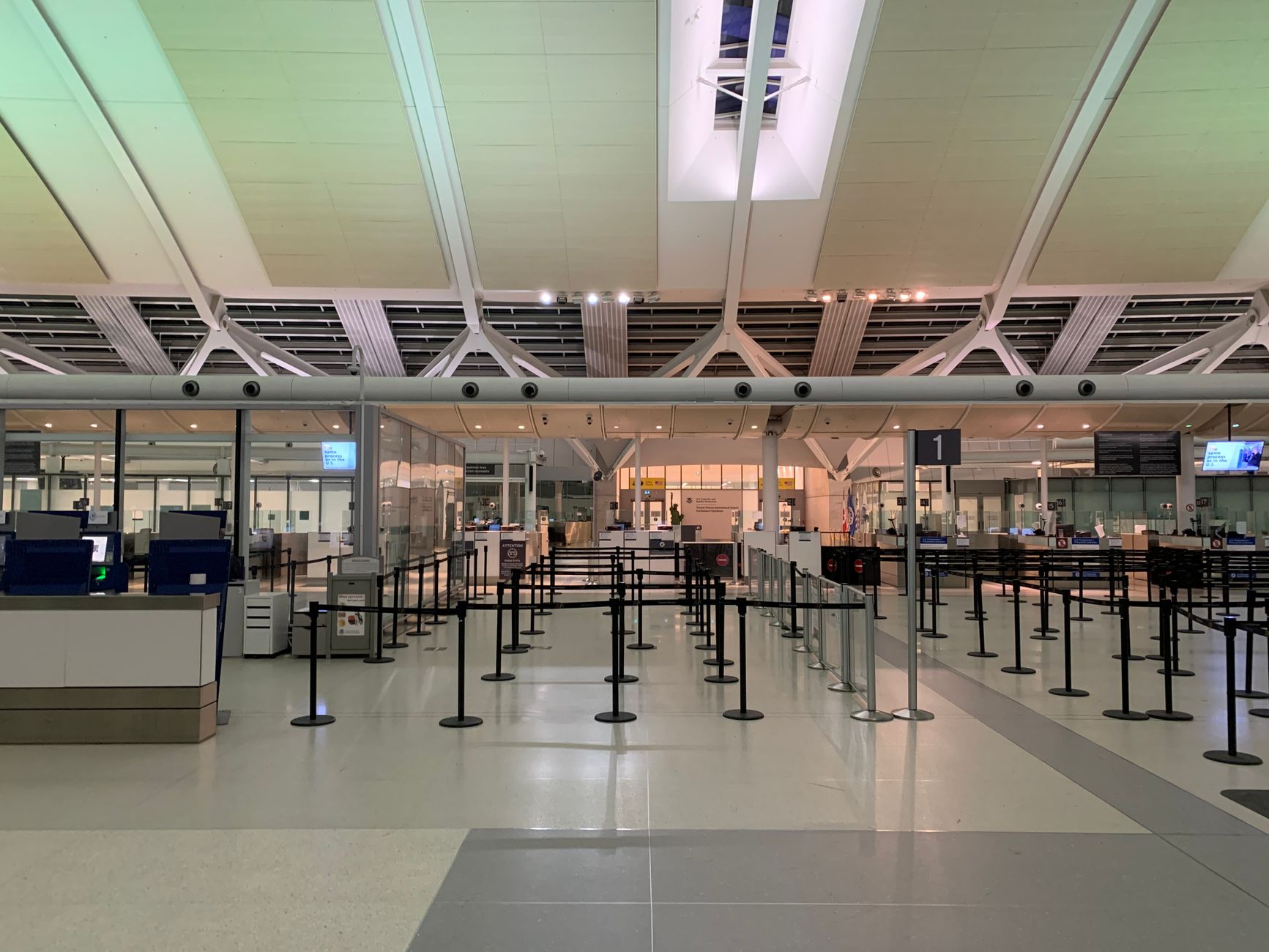 A controlled passenger checkpoint separates public and secure areas inside a transportation terminal.