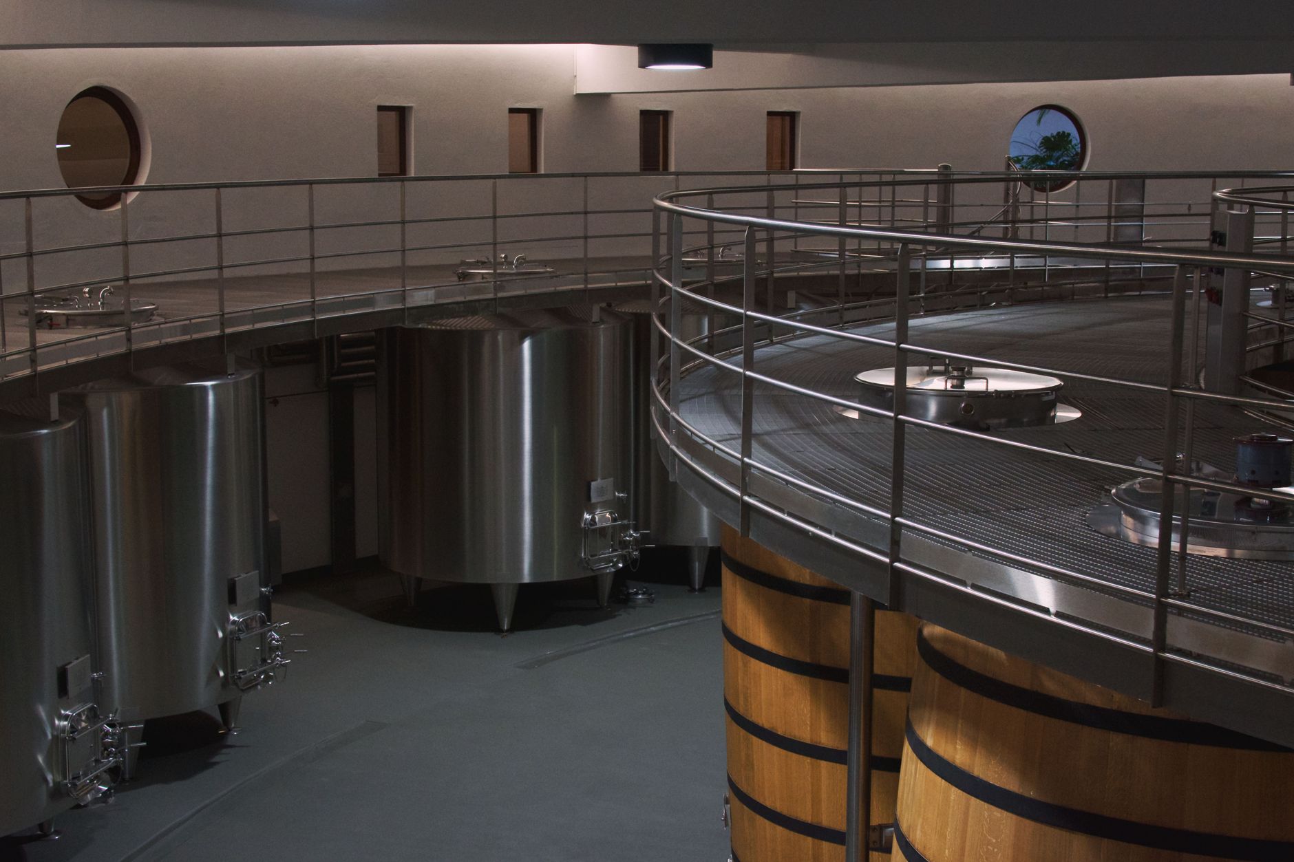 Narrow winery corridor with tanks and painted concrete floor