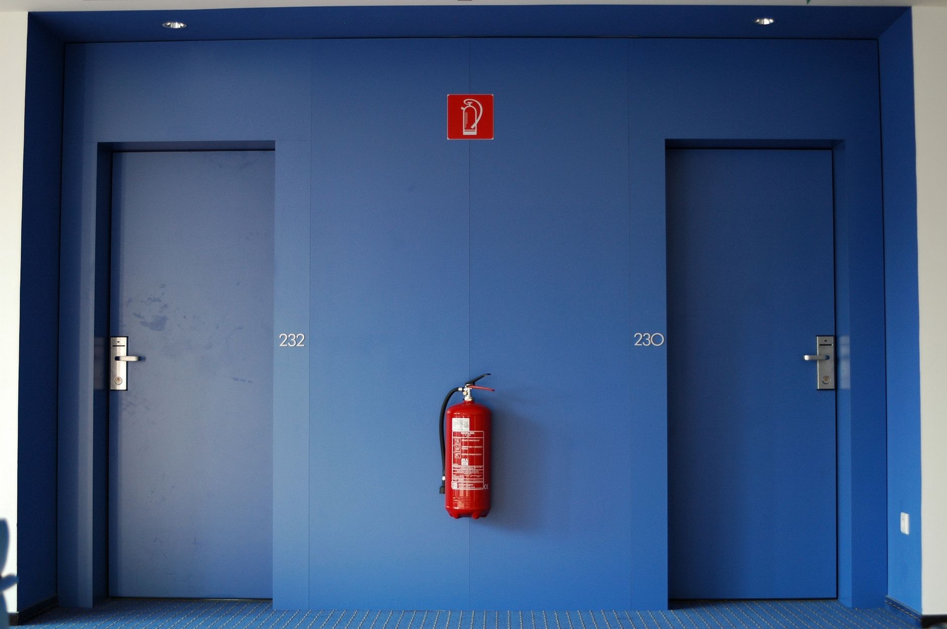 A clearly marked and unobstructed fire exit in a commercial building, an example of an operational safety issue a patrol robot can monitor.