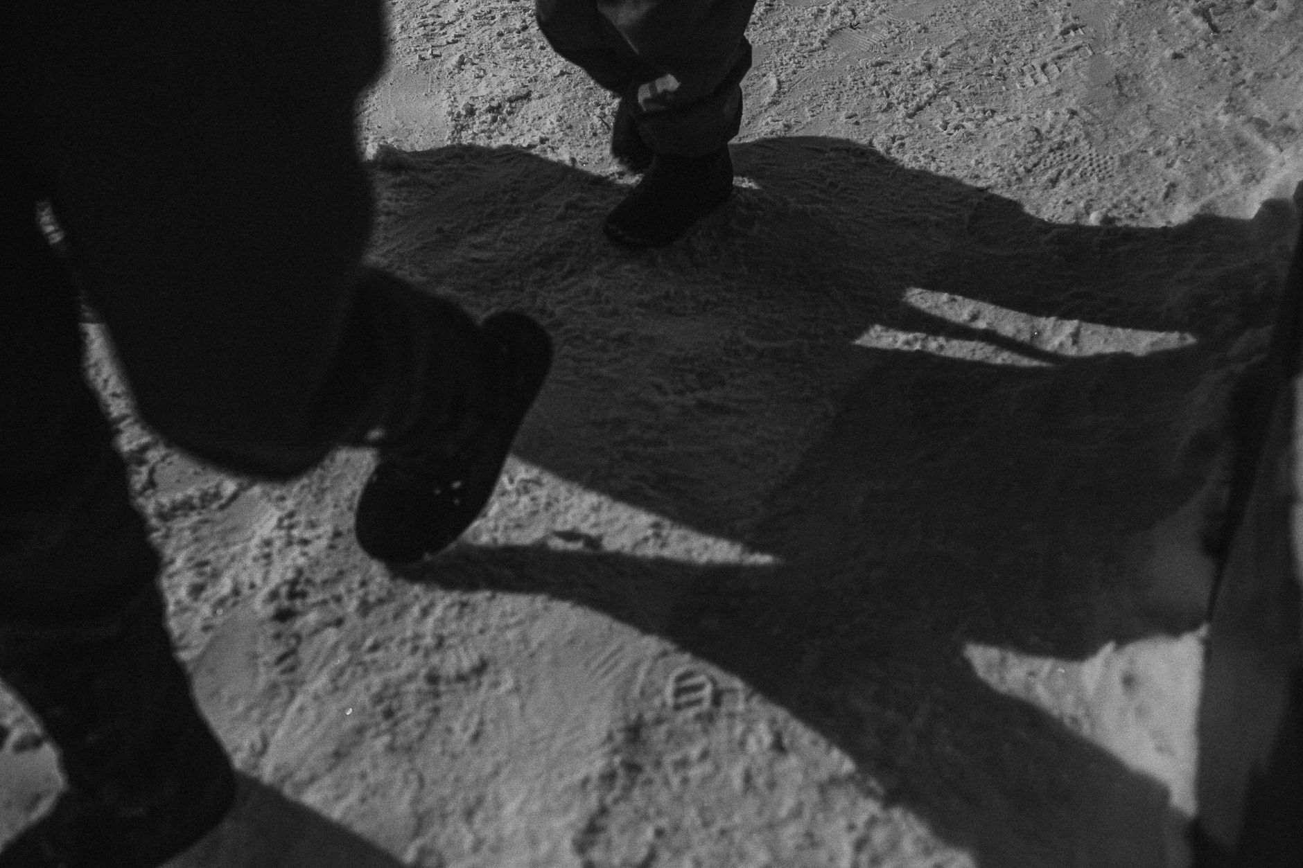 Snow-covered boots on a floor mat at a building entrance