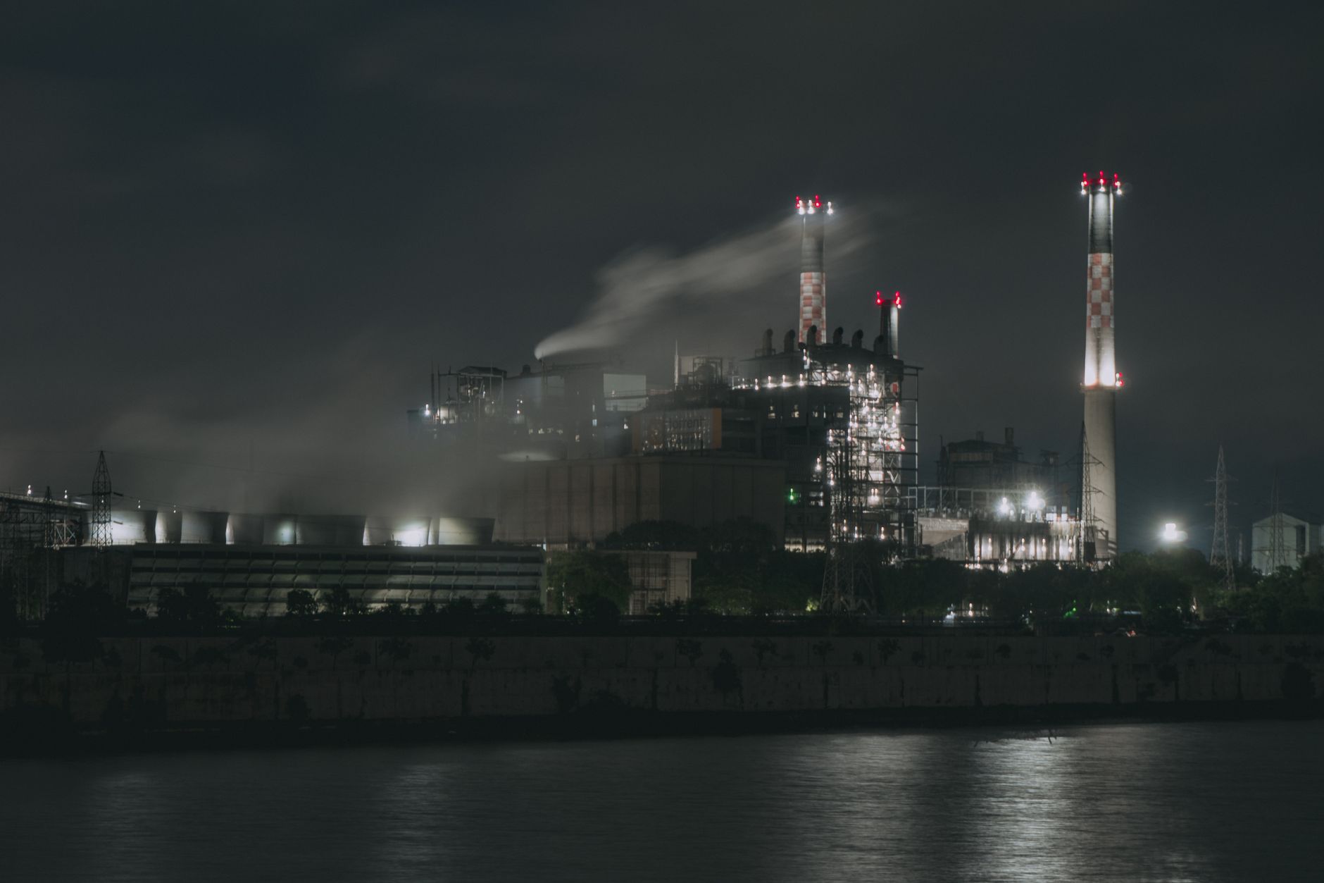 Industrial building exterior at dusk with parking lot lights