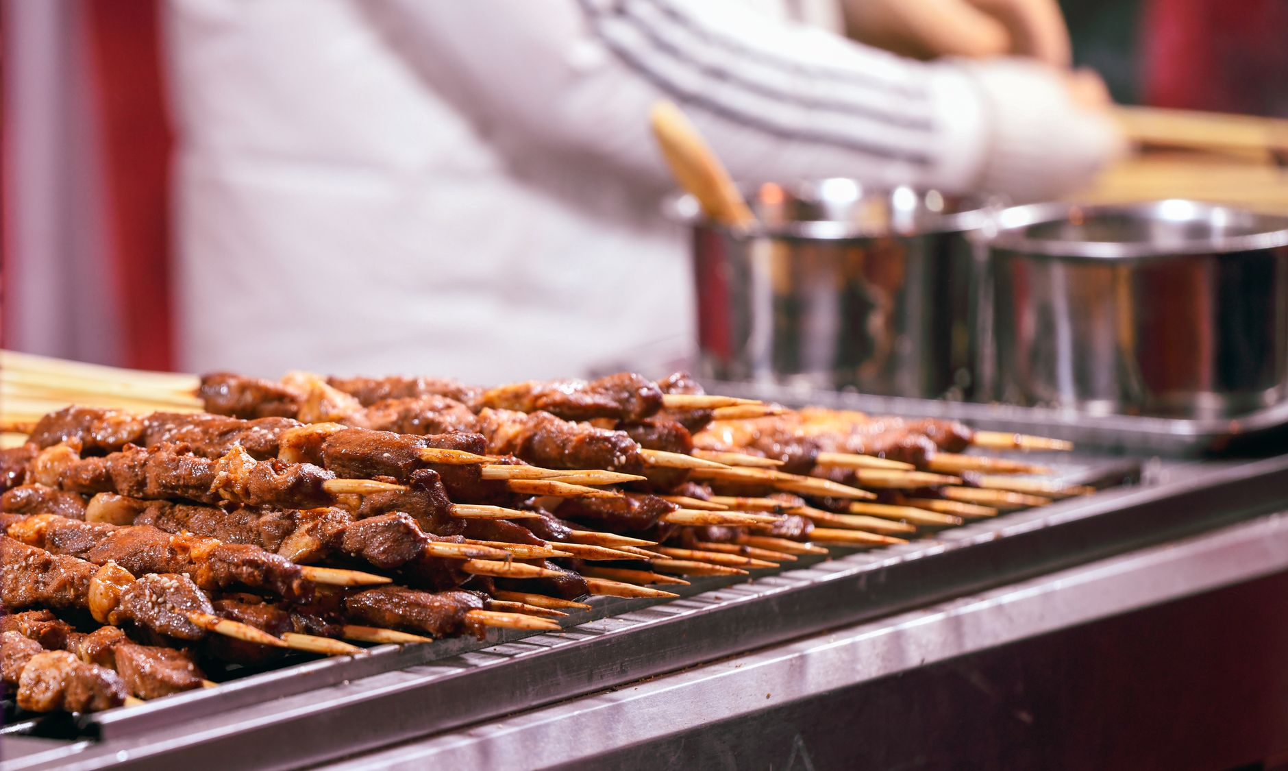 A busy commercial kitchen with employees working at the grill, illustrating the fast-paced QSR environment where automation is being introduced to improve efficiency.