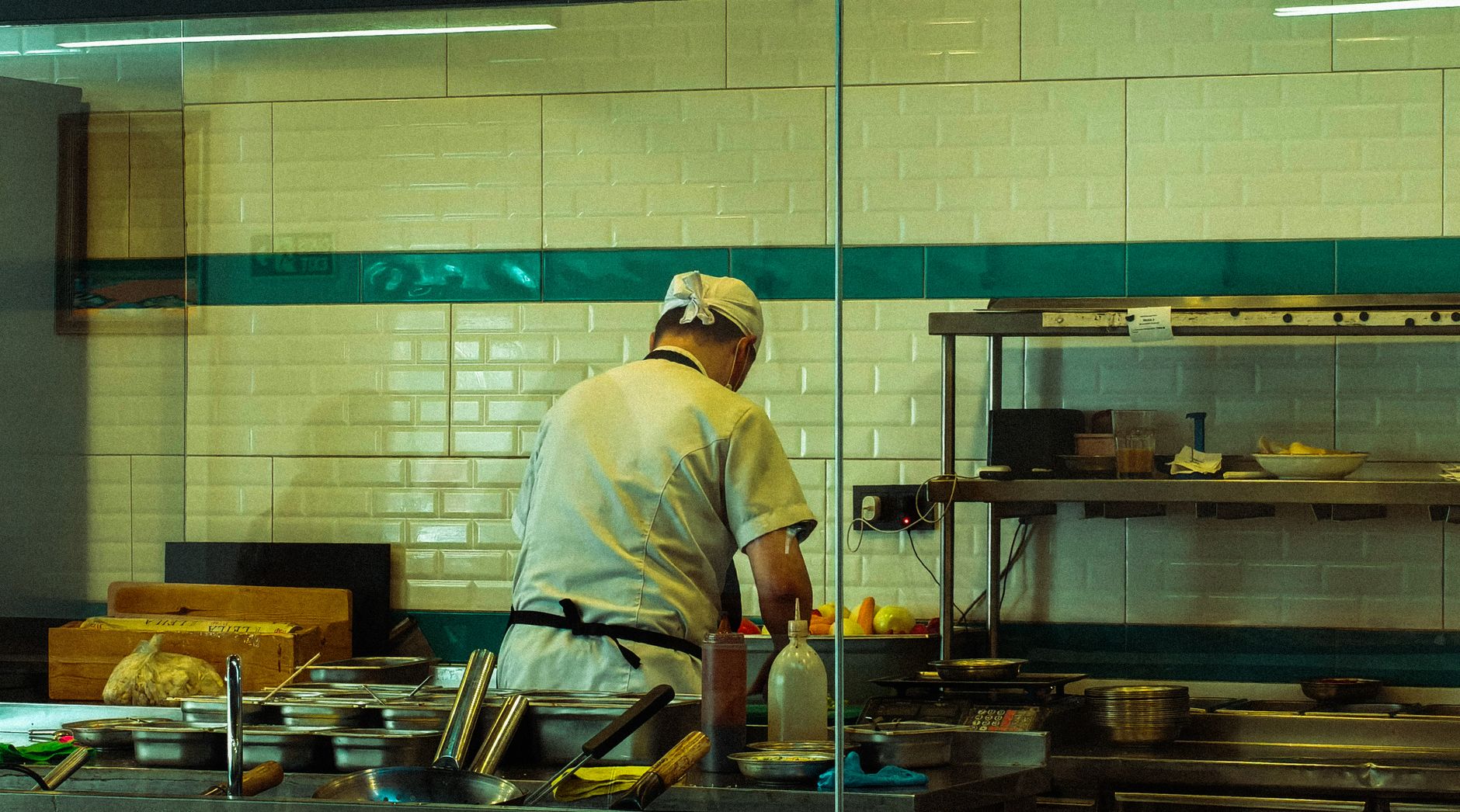 A restaurant manager trains a new employee, highlighting the human element and the importance of staff training when implementing new AI automation systems.
