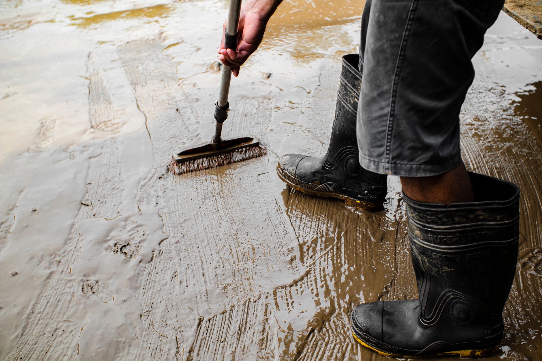 A damp concrete utility floor with residue and tight footing, showing the kind of slick surface that affects traction inside lift stations.