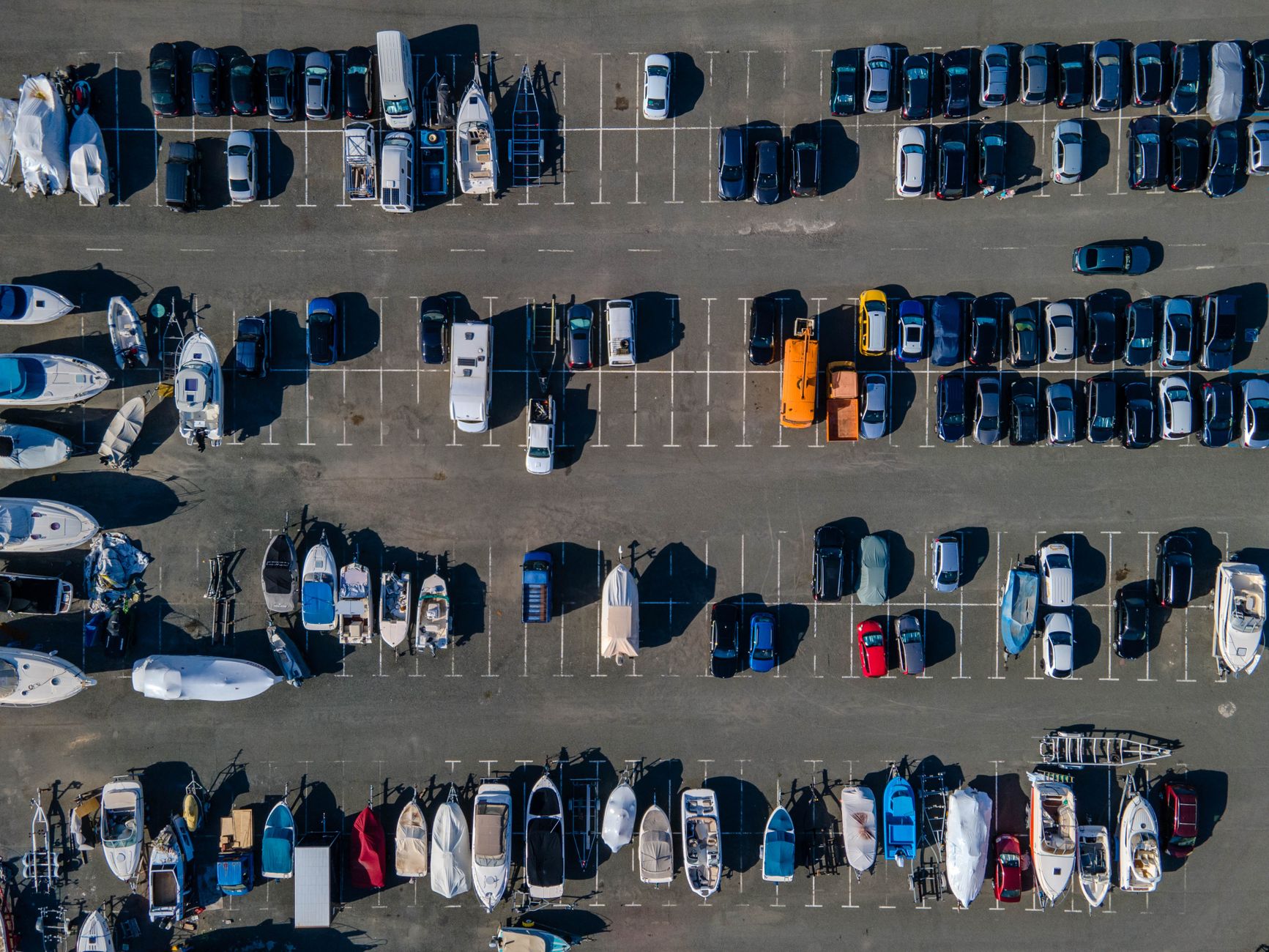 Aerial view of hundreds of vehicles arranged in long rows across a large outdoor auction lot.