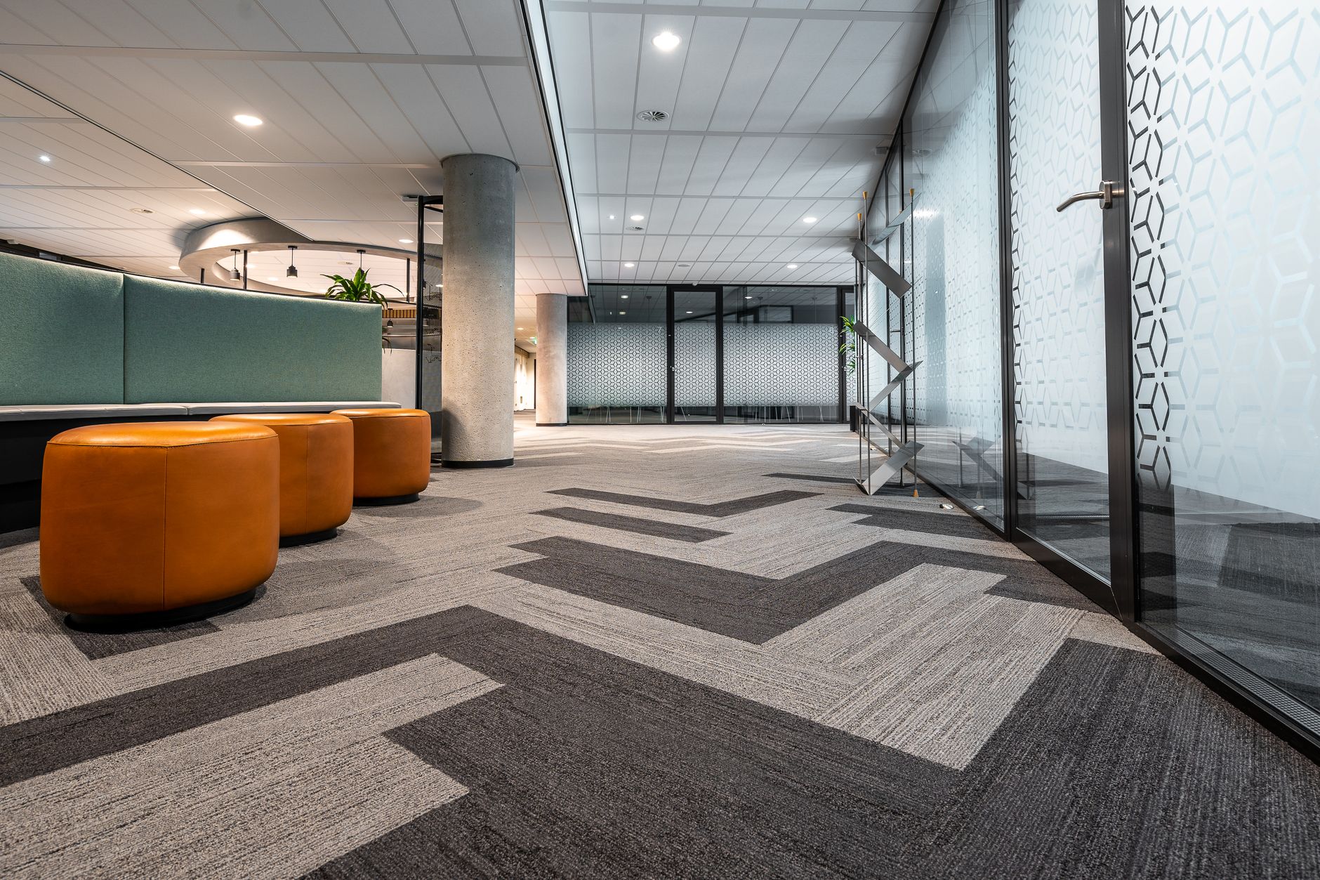 A worker vacuuming a high-traffic commercial carpet similar to a performing arts center lobby.