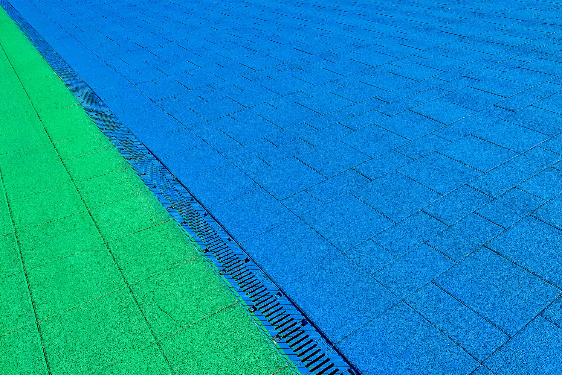 A close view of a trench drain set into concrete, the kind of floor detail that affects traction, runoff handling, and safe robot routing in a bus bay.