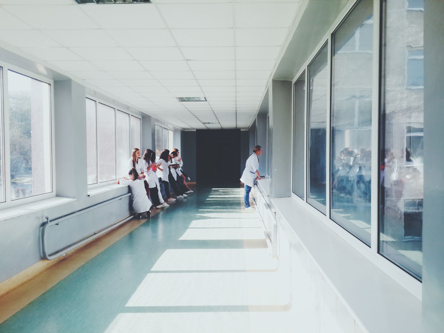 A long, bright, and impeccably clean hospital corridor, showcasing the high standard of hygiene achievable with consistent automated cleaning.