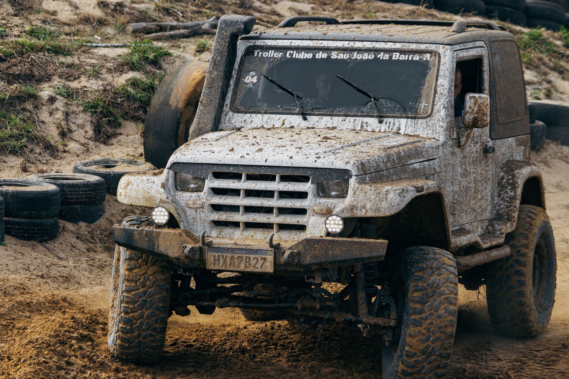 Mud-caked tractor tires and tracked-in dirt on a concrete floor, showing the kind of debris that challenges autonomous floor care.