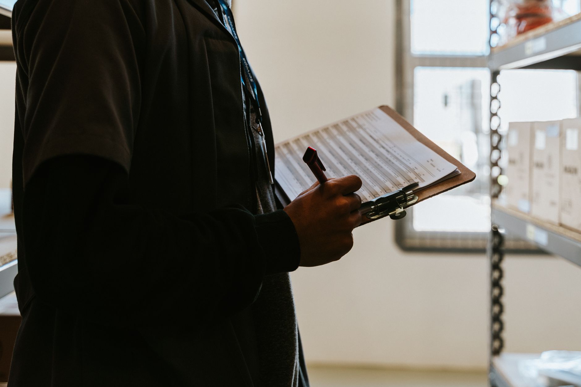 A facility team member inspecting an office common area with a clipboard, matching the article’s emphasis on workflow design before any pilot.