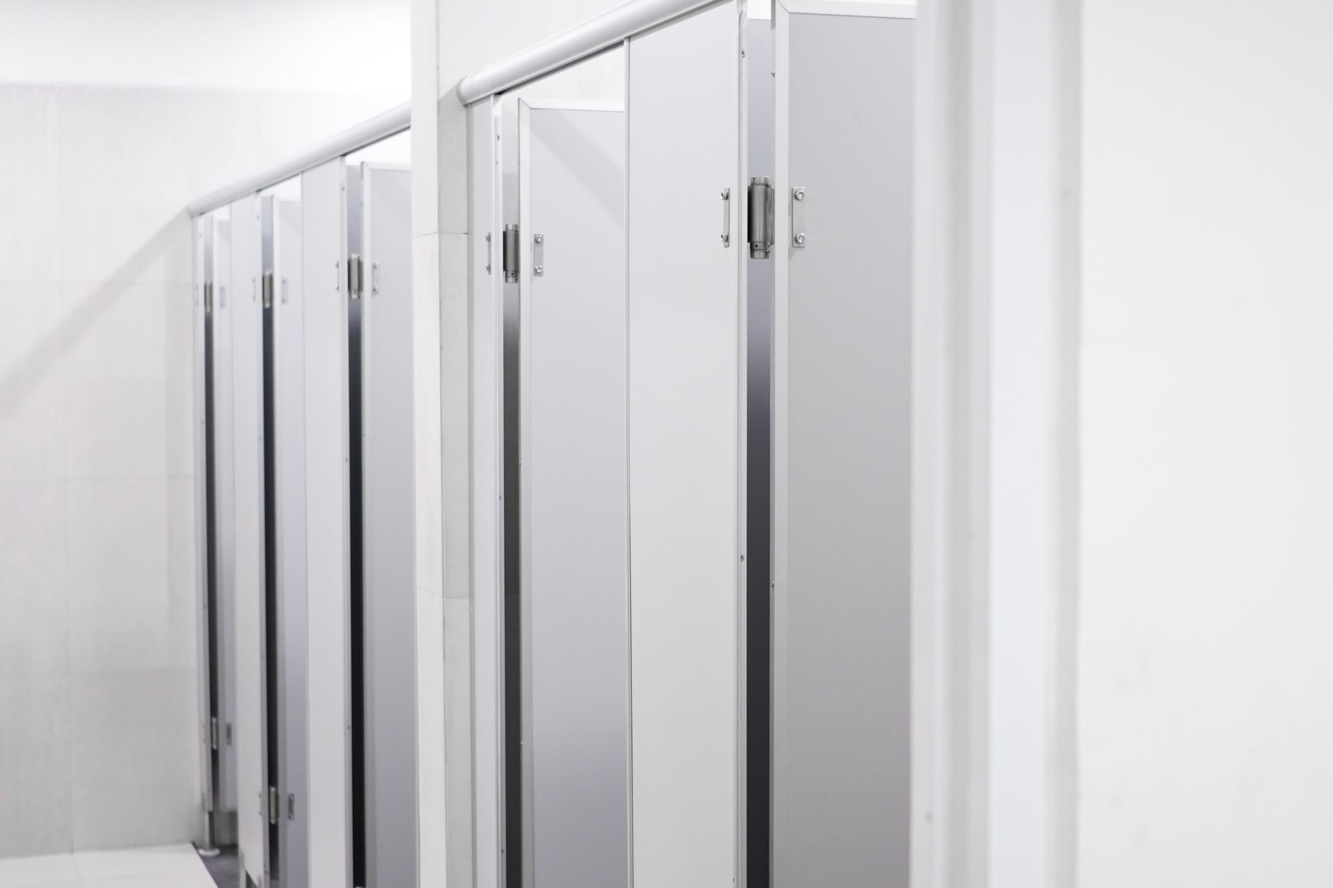 Modern office tower restroom with clean sink banks and circulation space, representing the environment where reset quality shapes tenant perception.