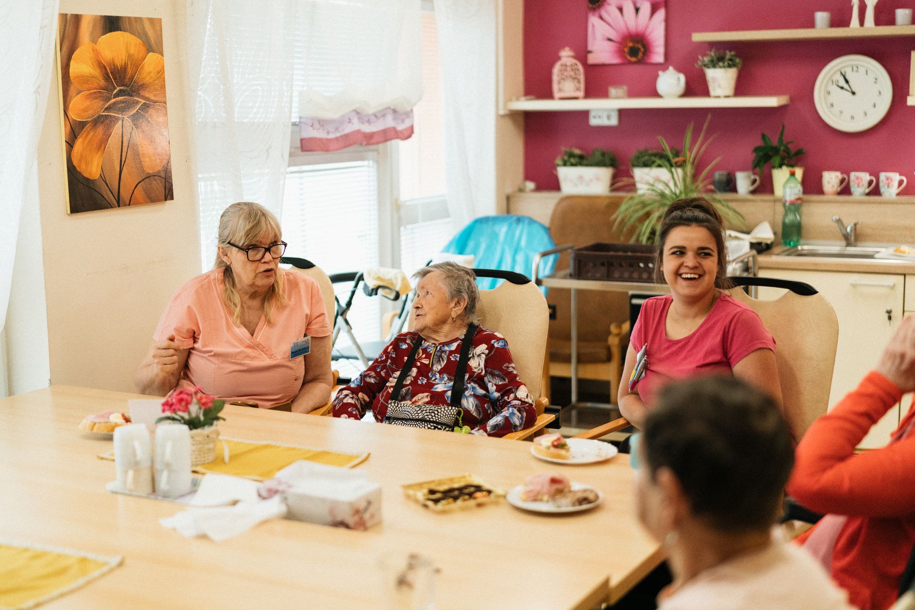 A quiet senior care dining room set for meal service inside a skilled nursing facility.