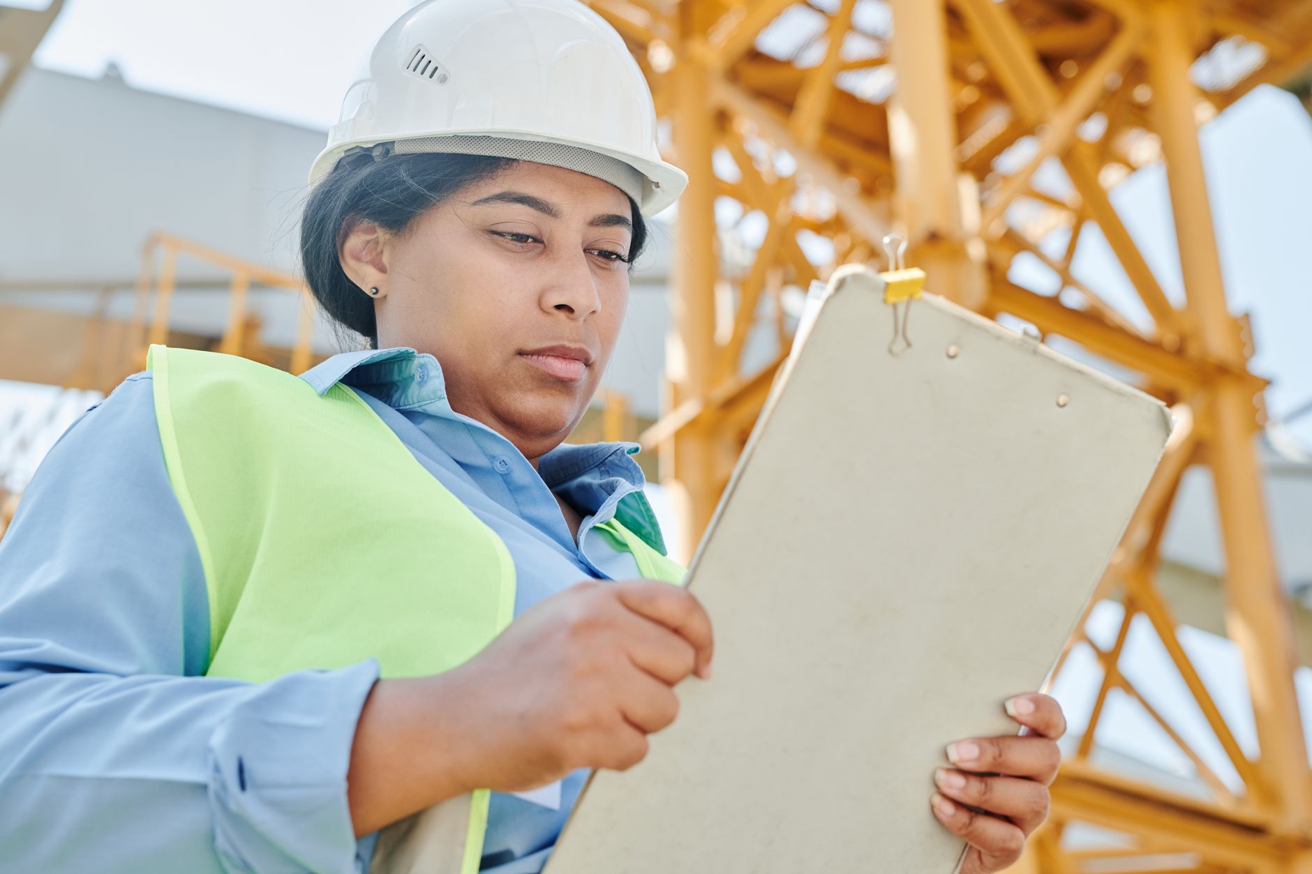 A plant or facility worker reviewing an inspection checklist during a sanitation or safety round.